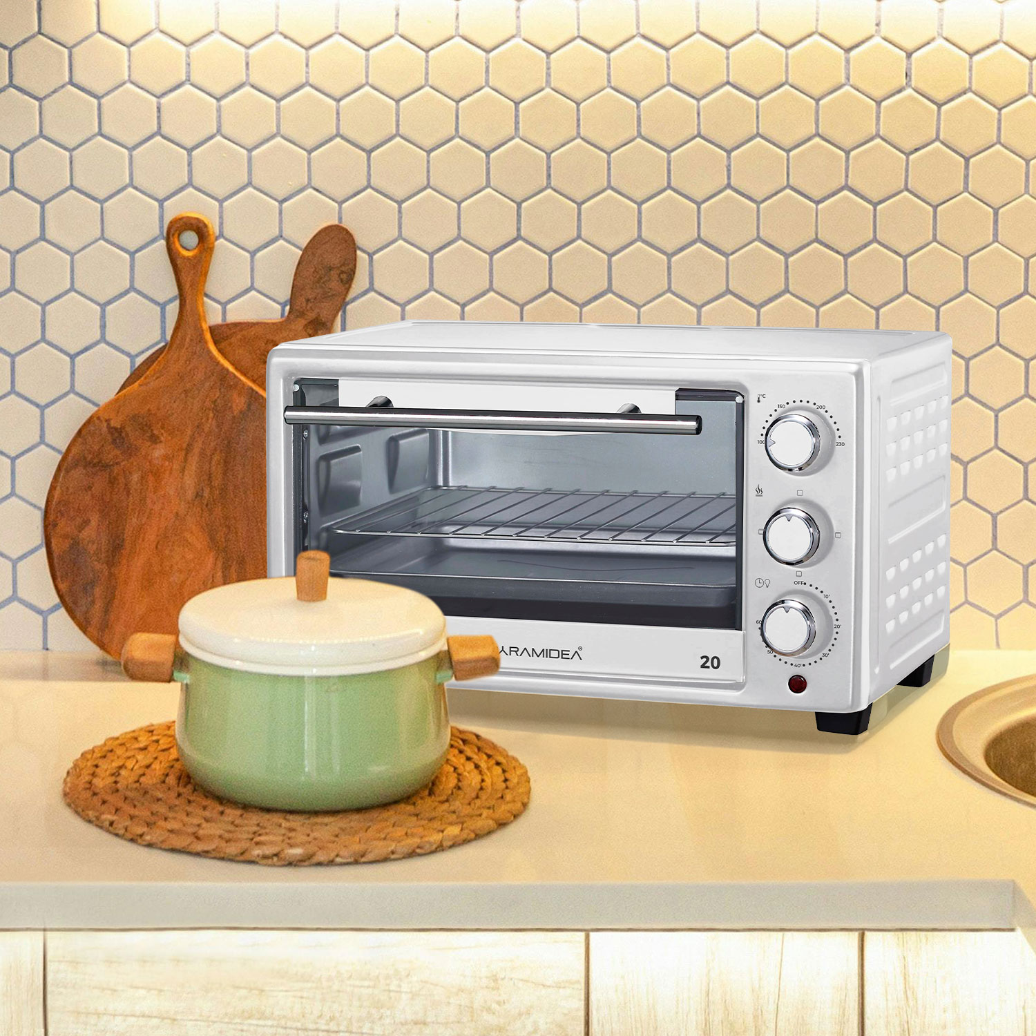 Forno bianco Paramidea su un bancone con pentola verde e tagliere in legno, parete beige.