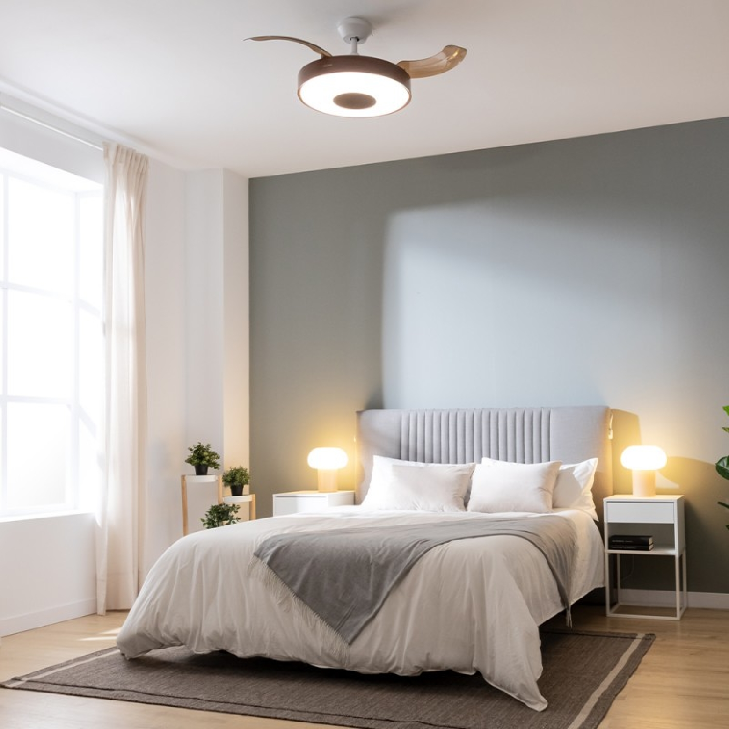 Dormitorio con cama, lámparas y ventilador de techo, iluminación cálida.