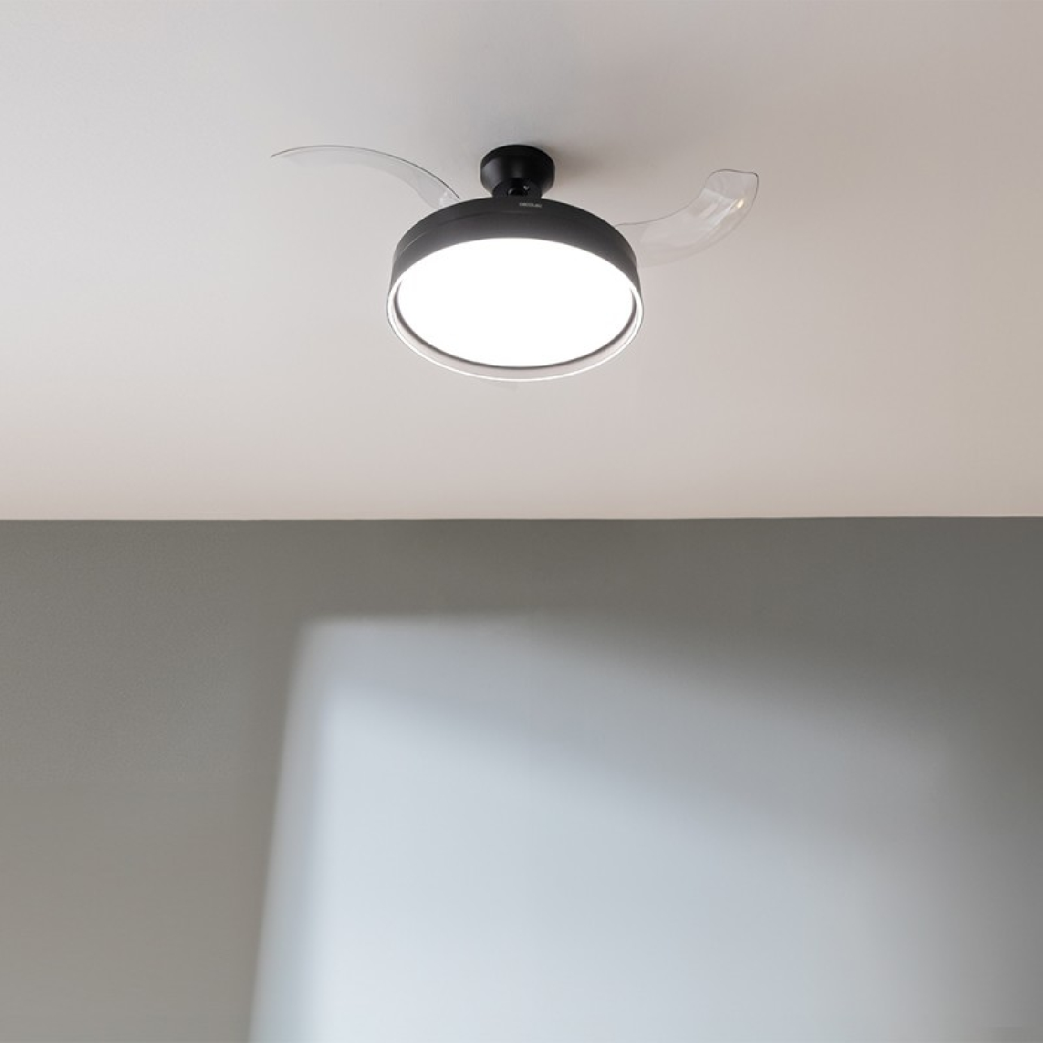 A black and clear ceiling fan with a light. The fan is centered in a white ceiling.