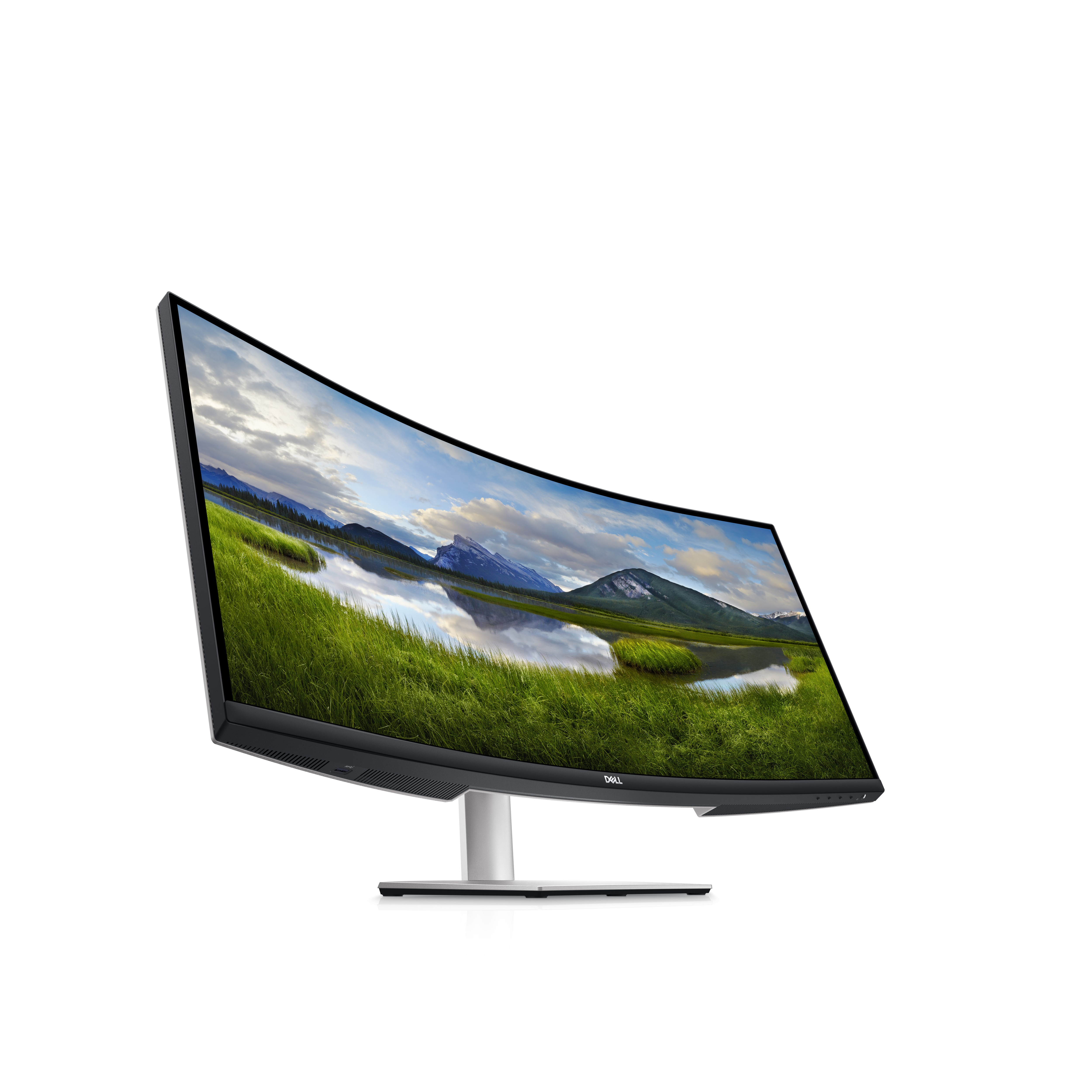 Monitor Dell curvo muestra un campo verde y montañas. El soporte es plateado.