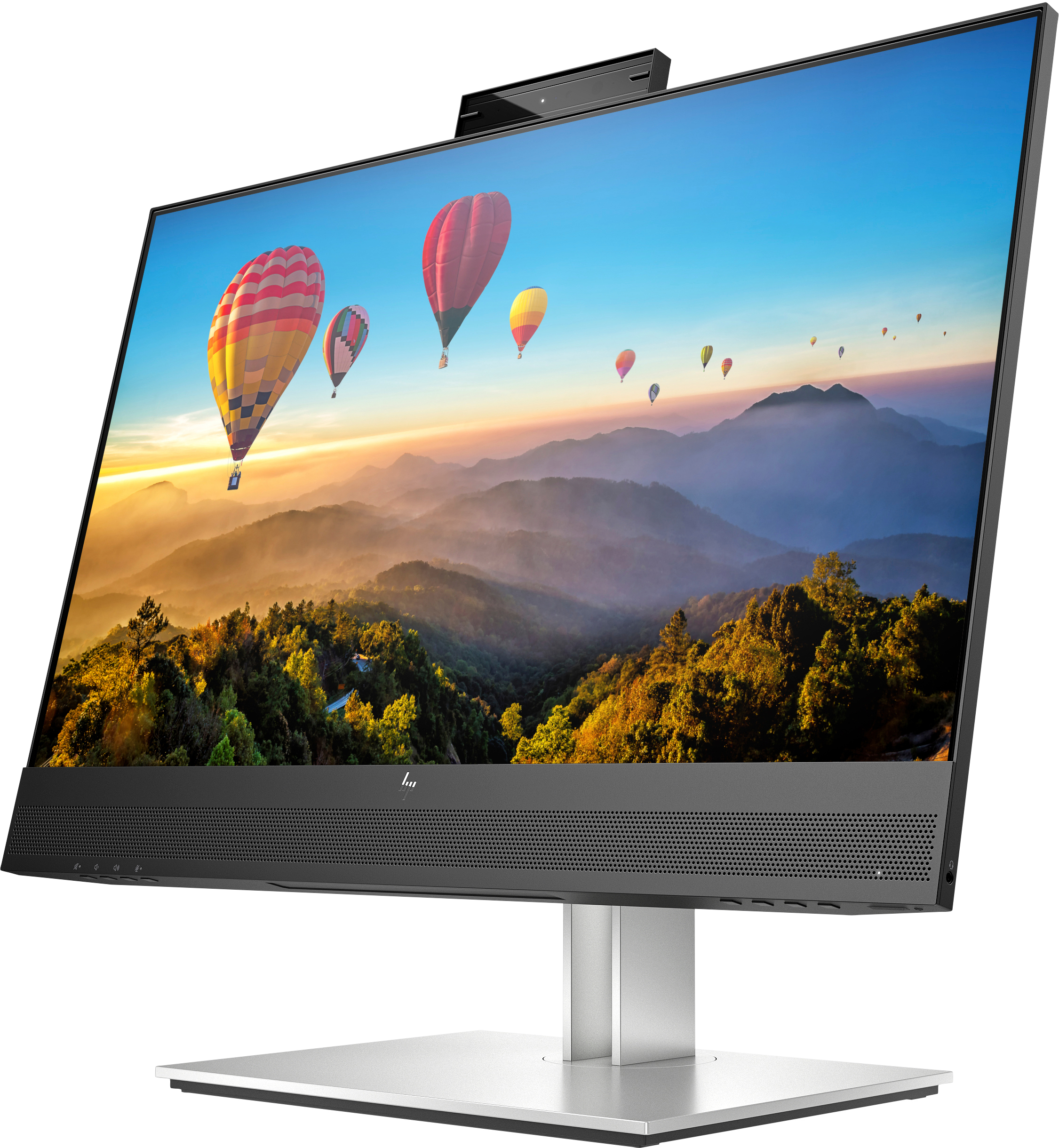 An HP monitor displays hot air balloons over a forest and mountains, with a webcam on top.