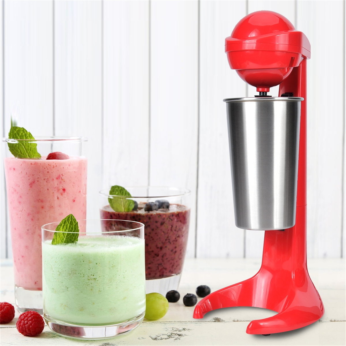 Roter Milchshake-Maker mit drei Gläsern Smoothies. Grüne, rosa und lila Smoothies befinden sich in den Gläsern.