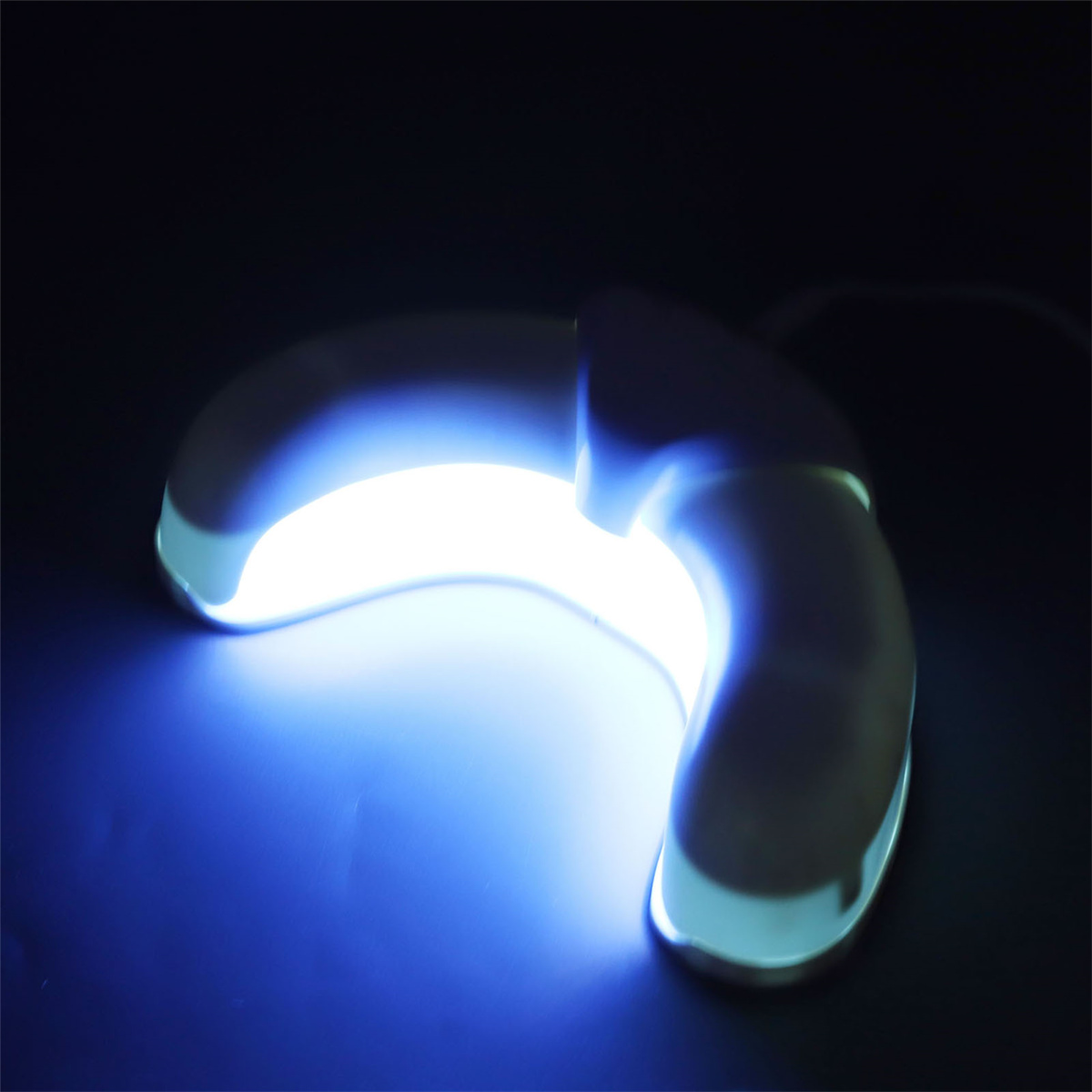 Eine weiße, halbmondförmige UV-Lampe mit blauem Licht, das leuchtet.