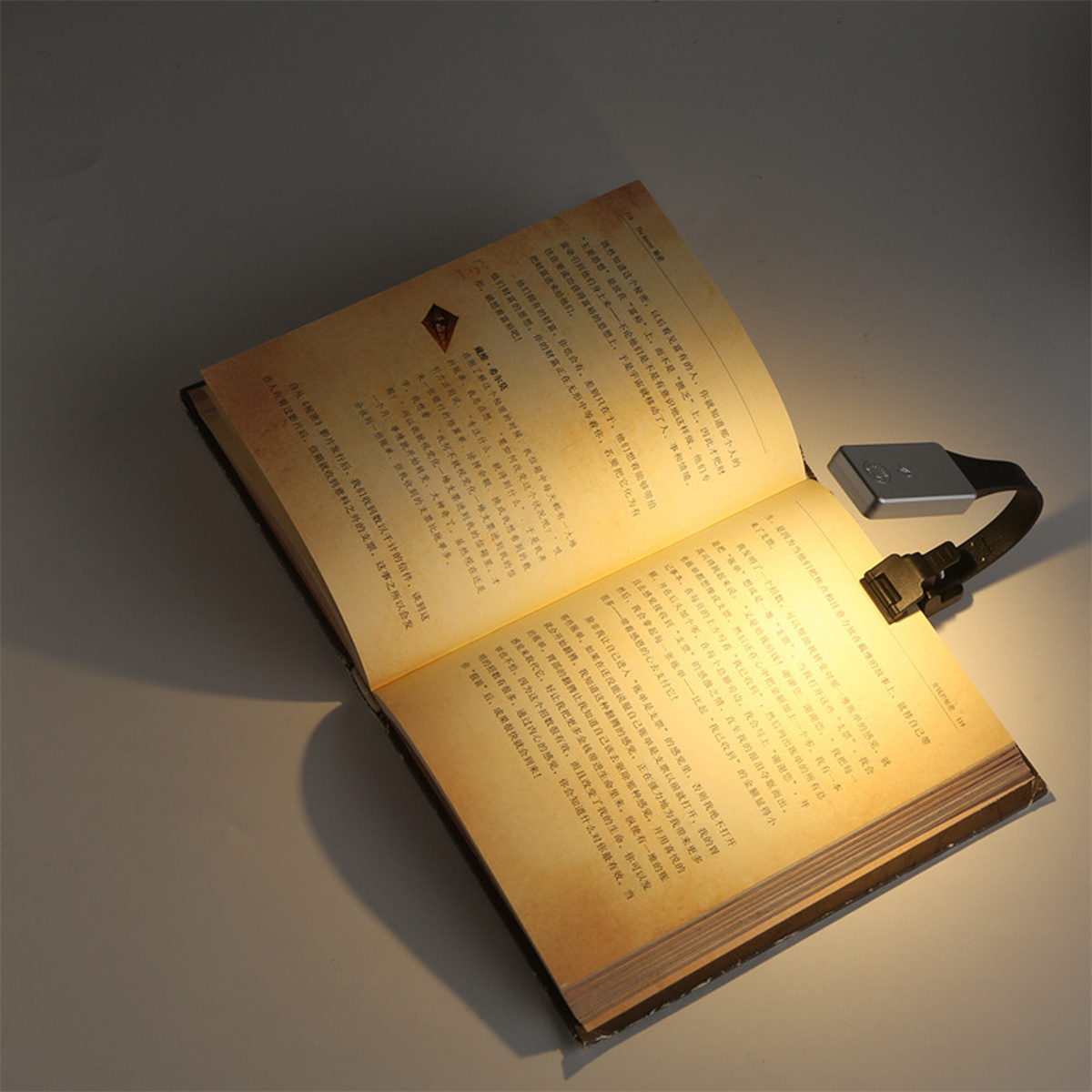 Ein Buch mit einem kleinen Leselicht, das daran befestigt ist.