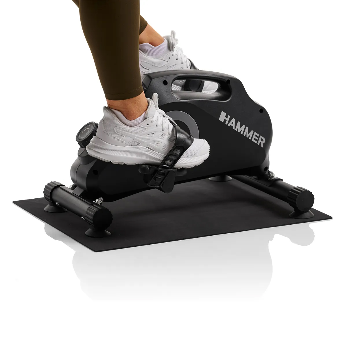 Heimtrainer, Füße auf Pedalen, schwarze Matte, weißer Hintergrund, Marke HAMMER.