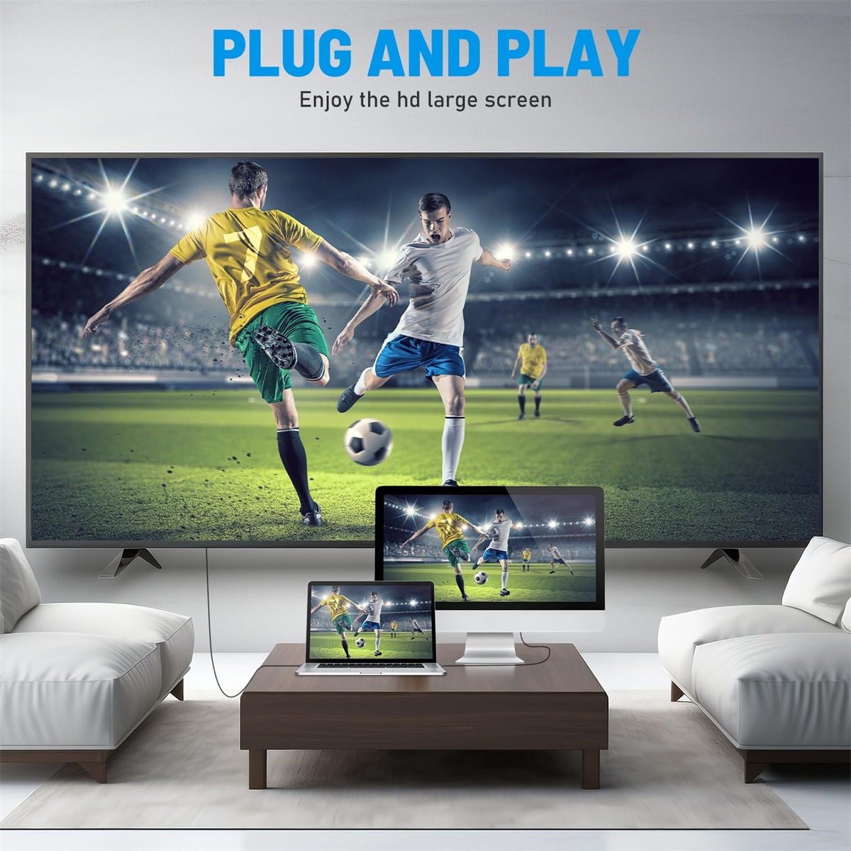 Ein großer Bildschirm-TV mit einem Fußballspiel, einem Laptop und einem Computermonitor auf einem Tisch.