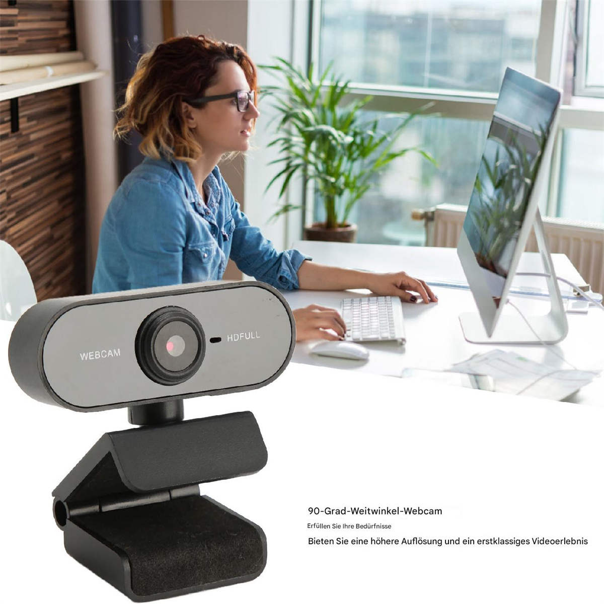Frau am Schreibtisch mit Computer, Webcam davor. Webcam ist grau.