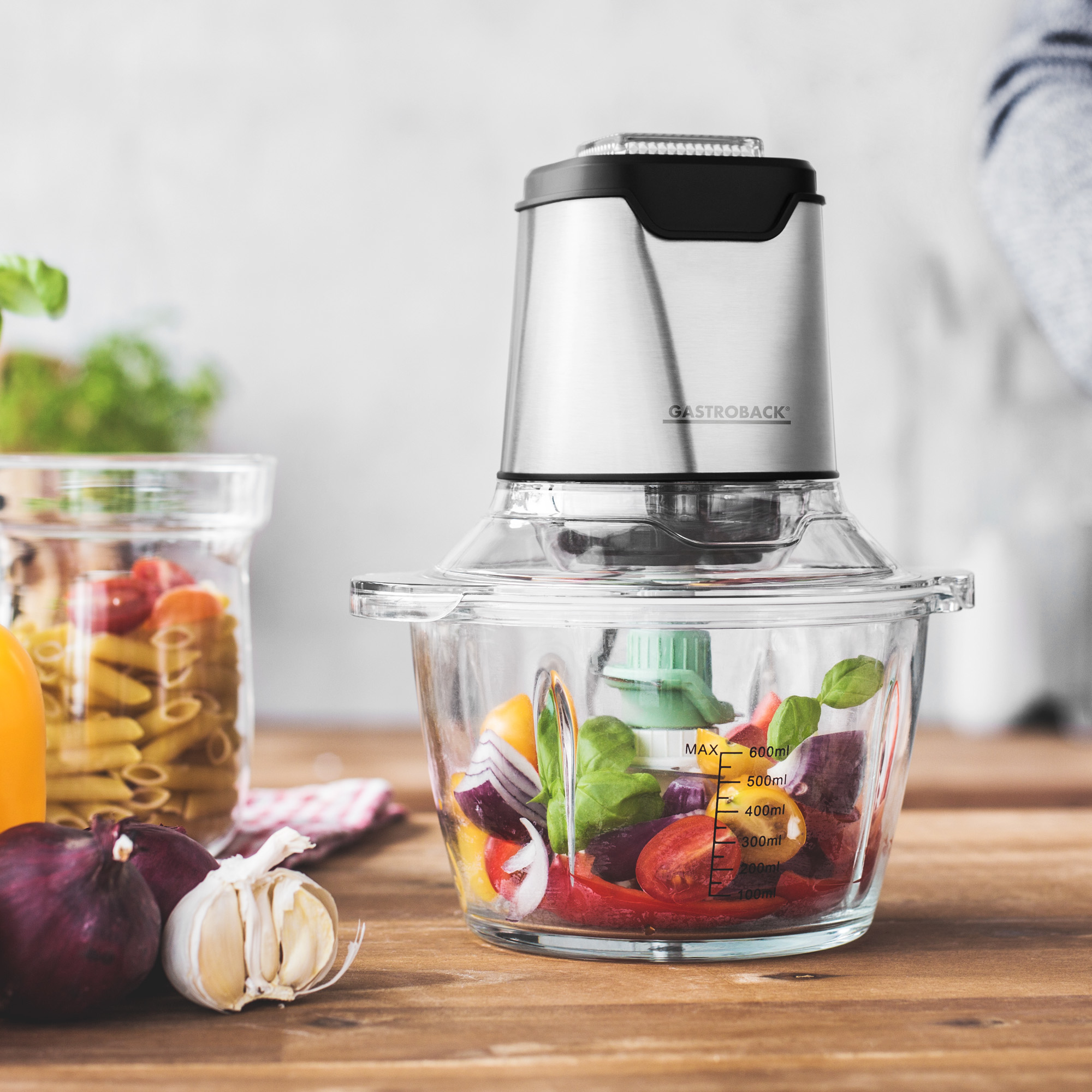 Robot da cucina con verdure all'interno. Ciotola di vetro, parte superiore in acciaio inox.