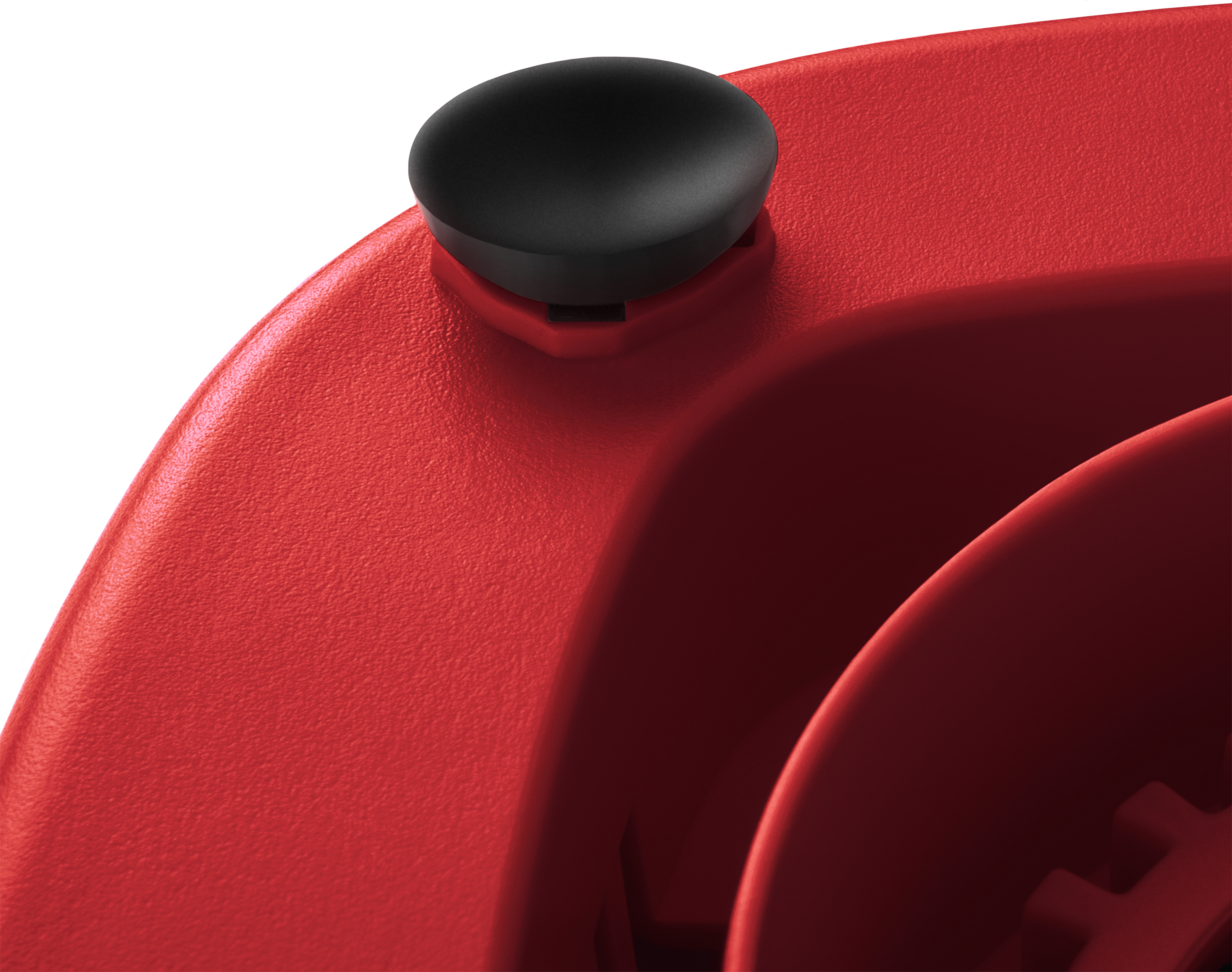 Zbliżenie czerwonego elementu blendera z czarnym przyciskiem. Powierzchnia jest teksturowana.