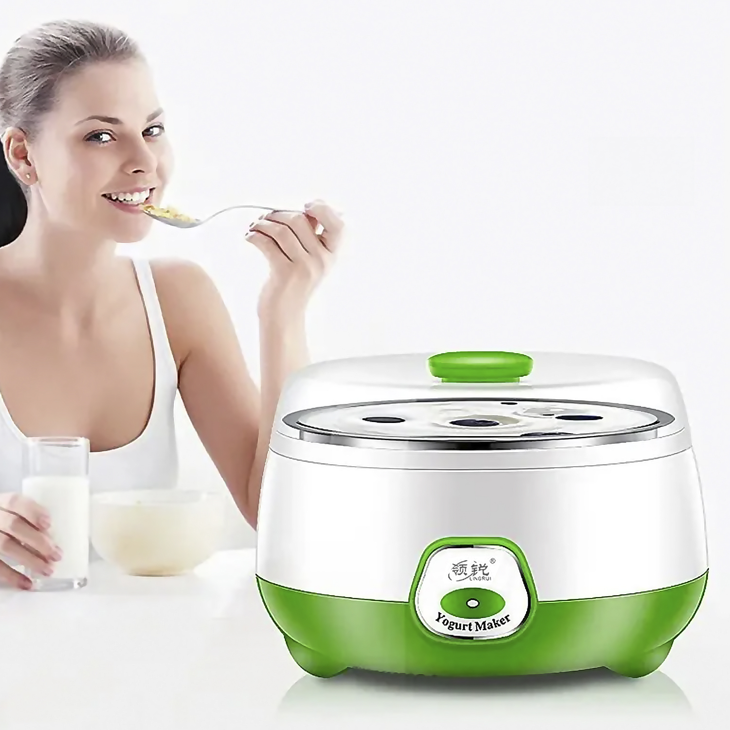 Una donna che mangia yogurt da un cucchiaio, con una yogurtiera sullo sfondo.