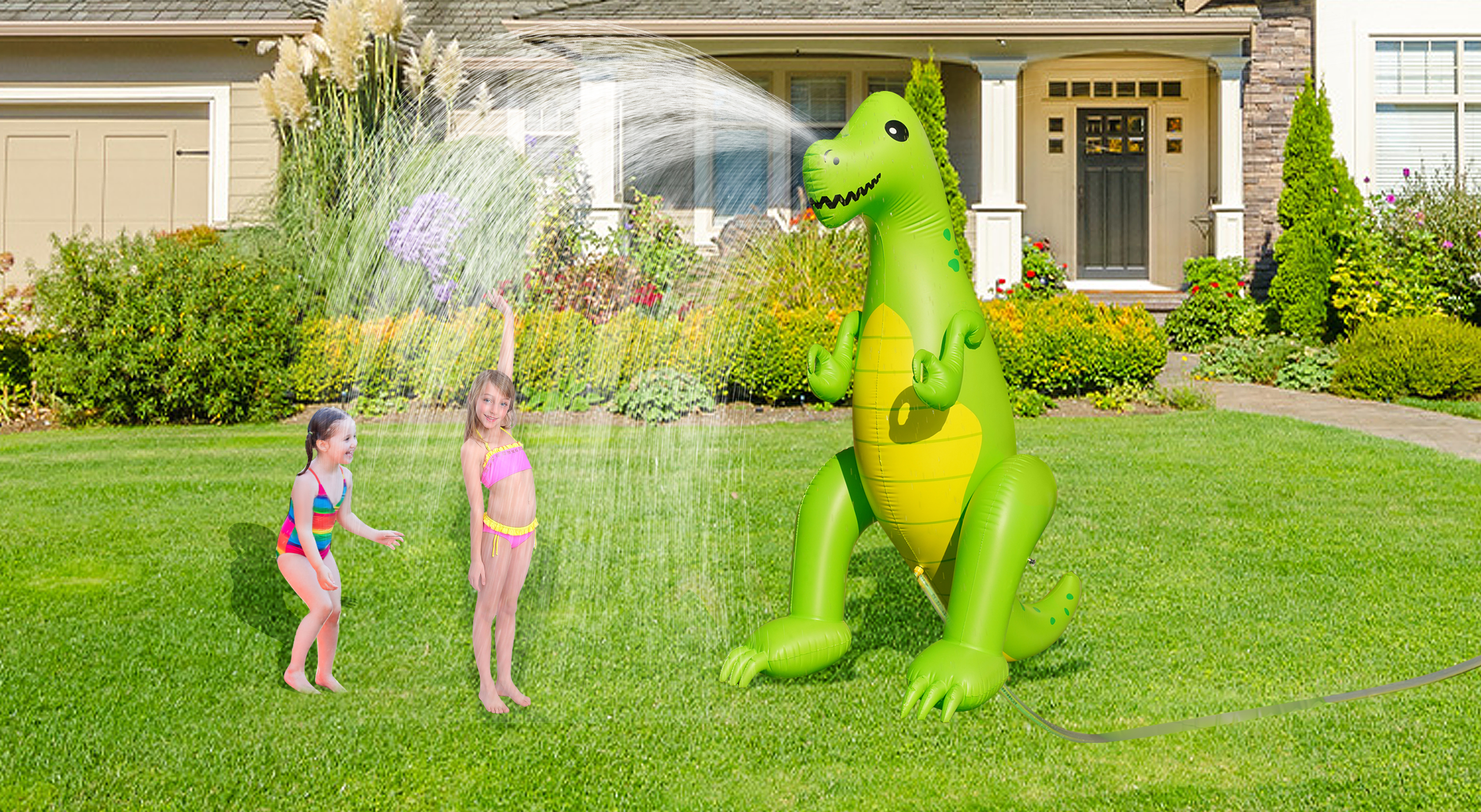 Zwei Mädchen spielen in der Nähe eines riesigen aufblasbaren grünen Dinosauriers, der Wasser spritzt.