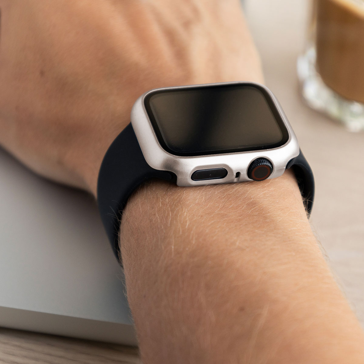 A person's wrist with a watch and a black band.