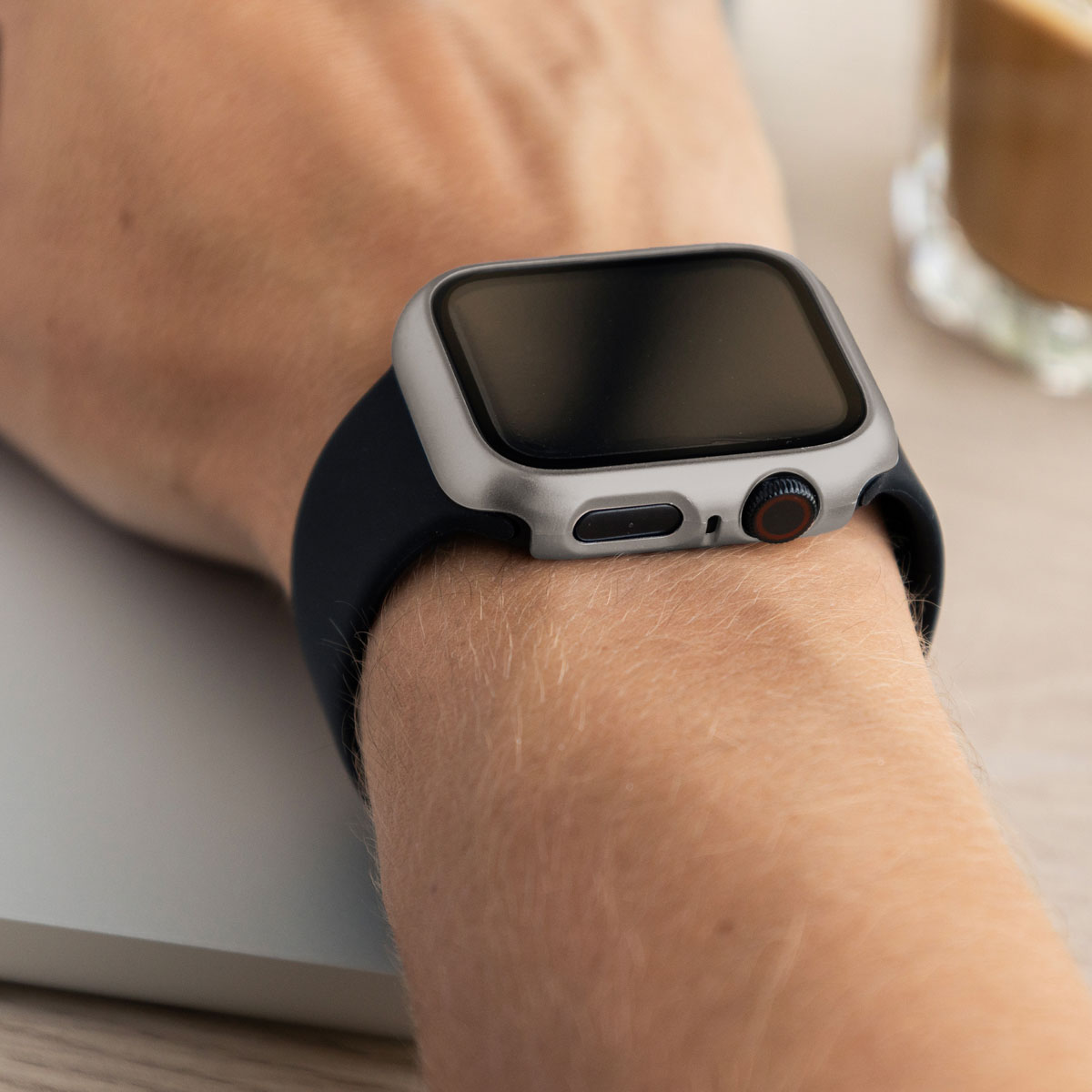 A silver Apple Watch with a black band is worn.