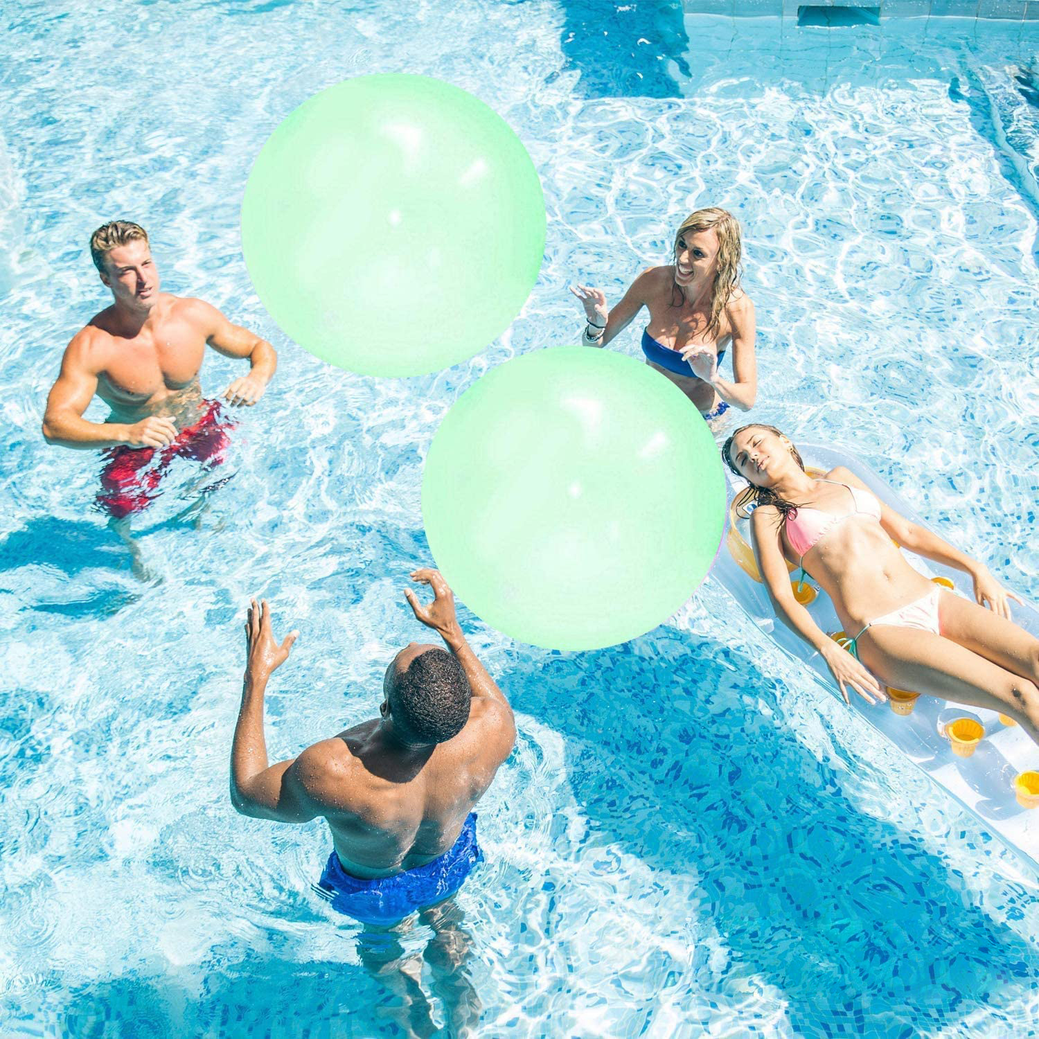 Gente jugando en la piscina con grandes bolas inflables verdes y acostados en un flotador.