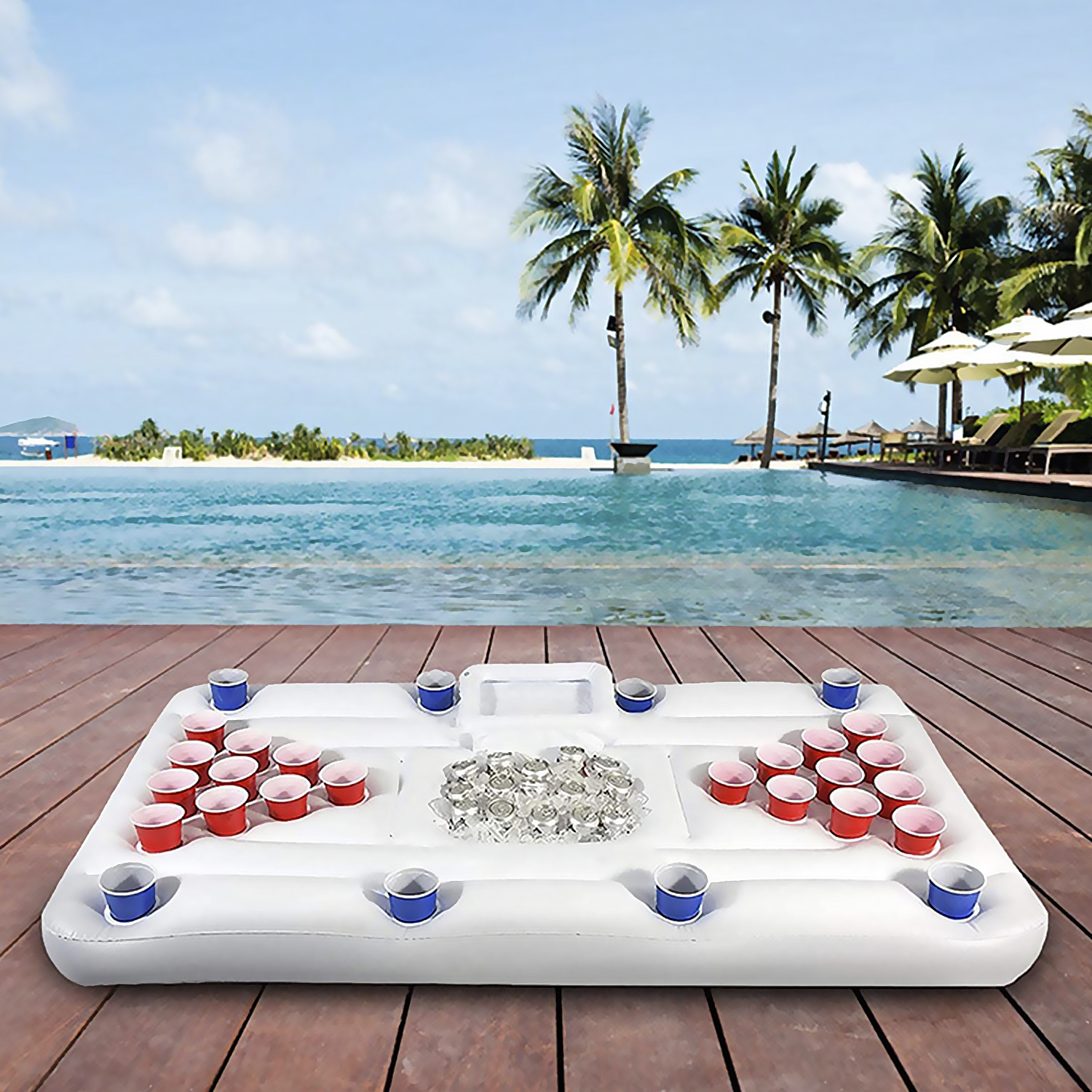 Mesa inflable de beer pong flotando en una piscina. Vasos rojos y azules, palmeras al fondo.
