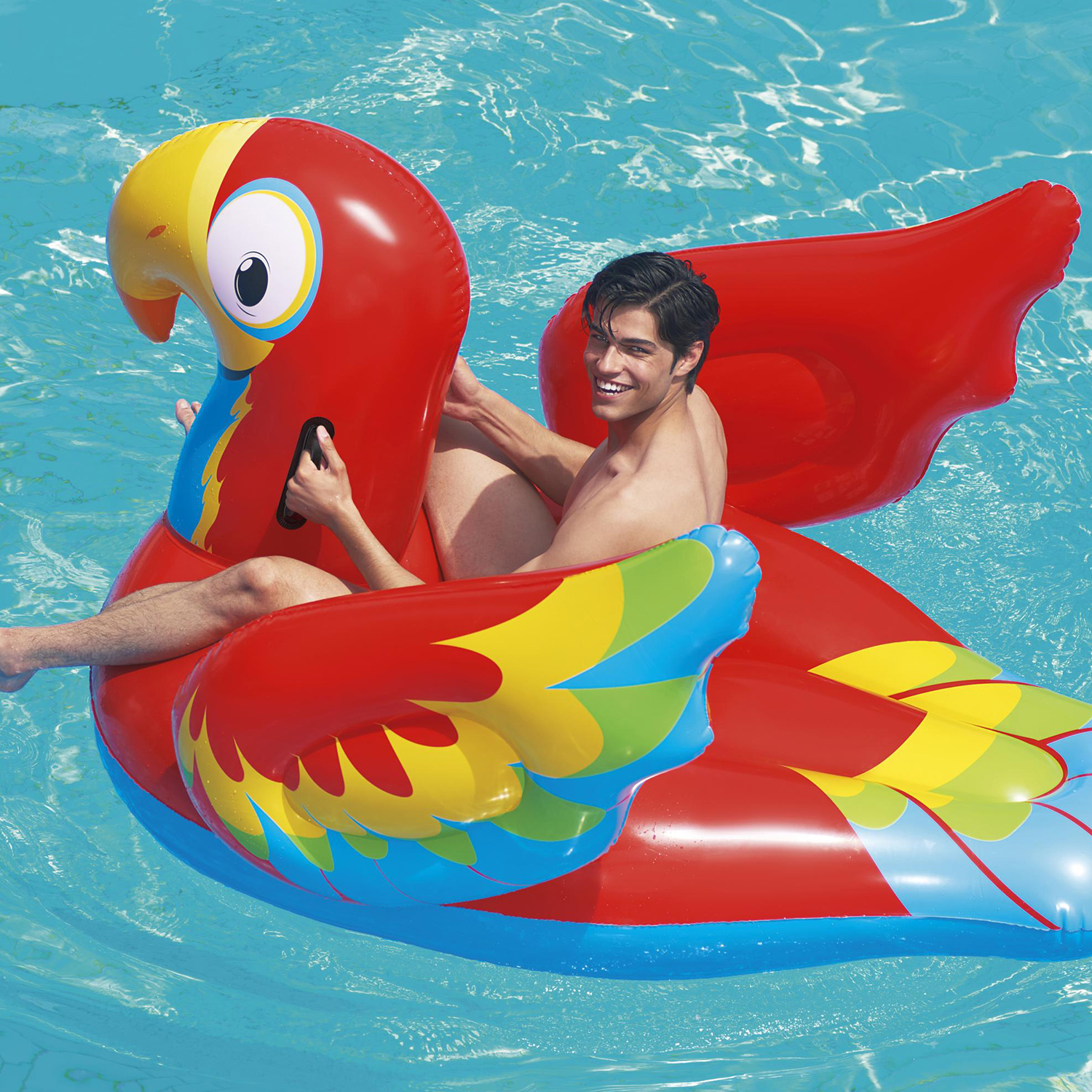 Un uomo cavalca un grande pappagallo gonfiabile in piscina.