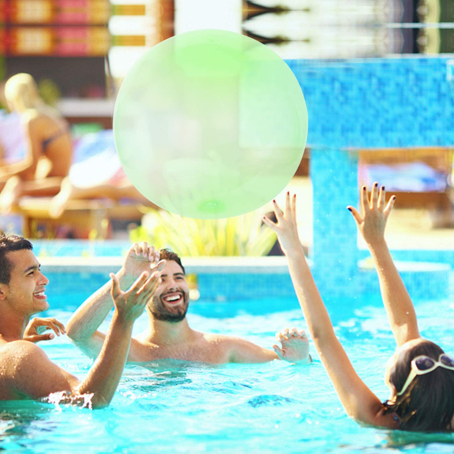 Tres personas en una piscina con una gran bola verde. Una persona está estirando el brazo.