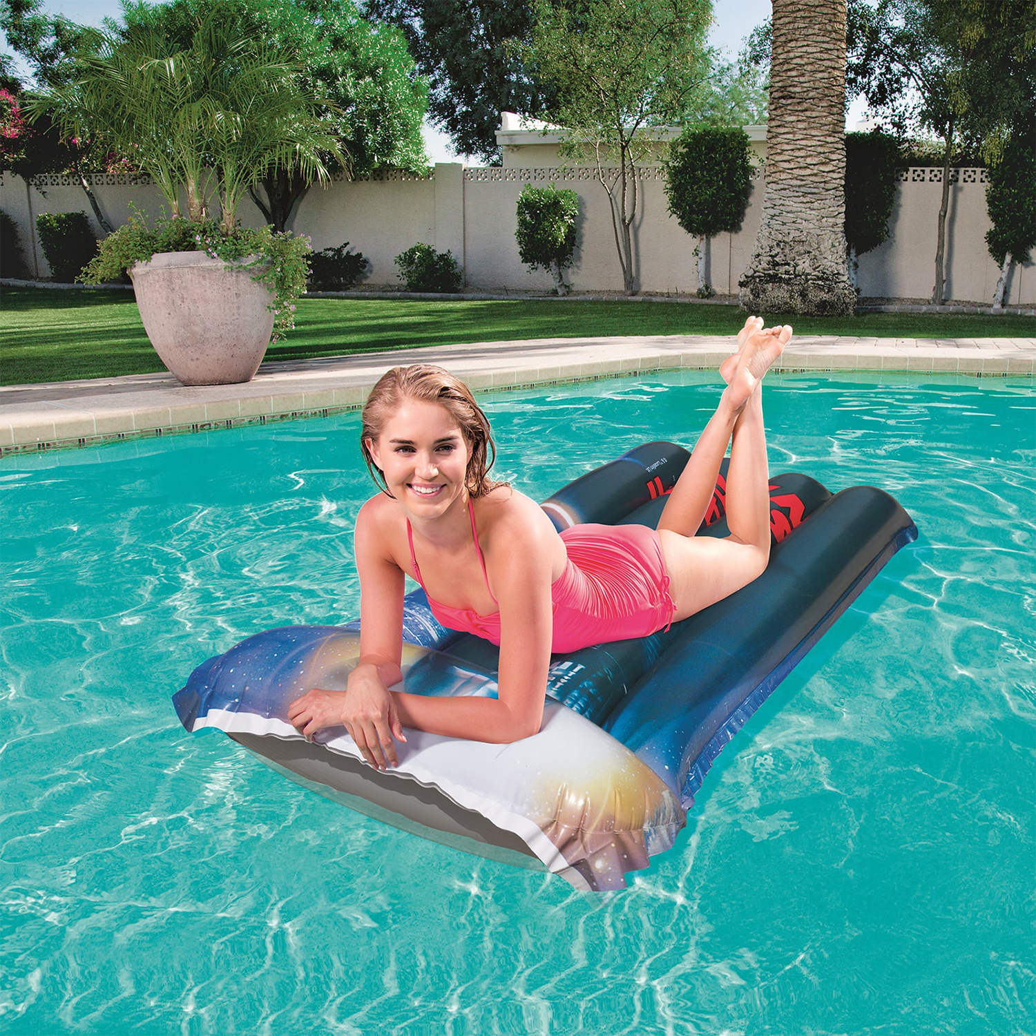 Una donna in costume da bagno sdraiata su un materassino in piscina in una giornata di sole.
