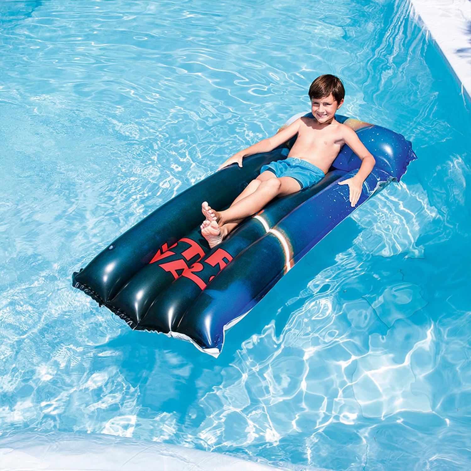 Ragazzo su un gommone blu in una piscina, giornata di sole.
