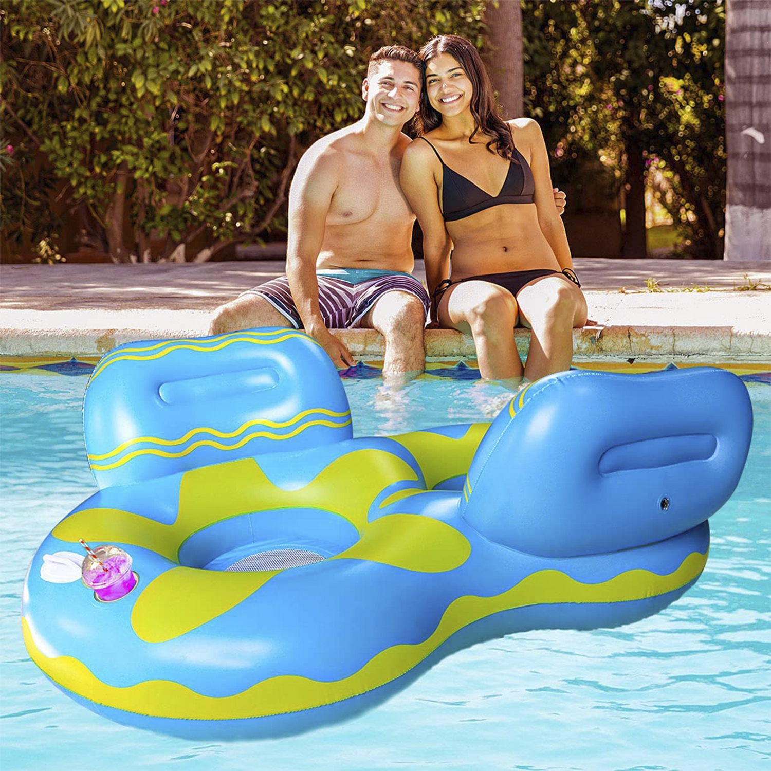 Una coppia seduta sul bordo di una piscina con un gonfiabile blu.