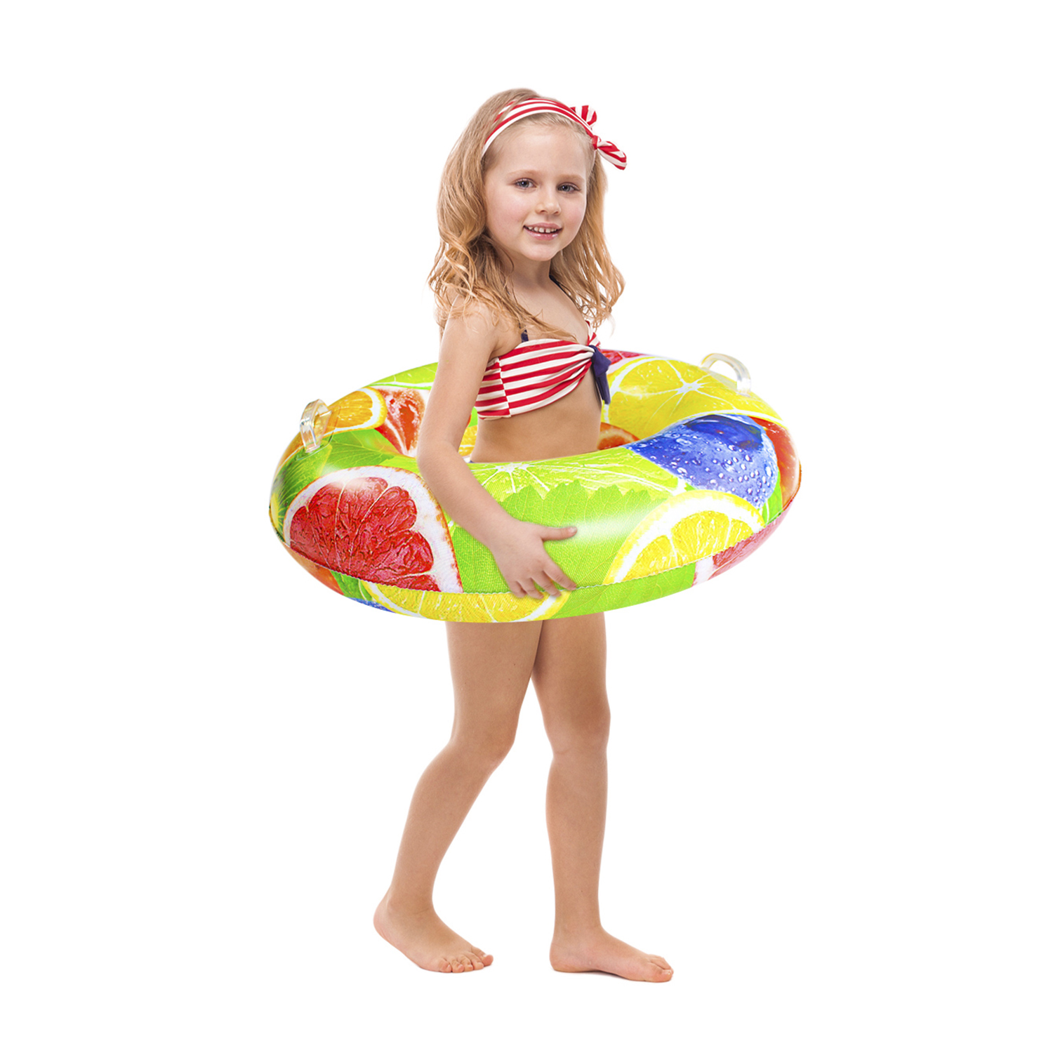 Una niña en traje de baño sosteniendo un flotador con estampado de frutas.