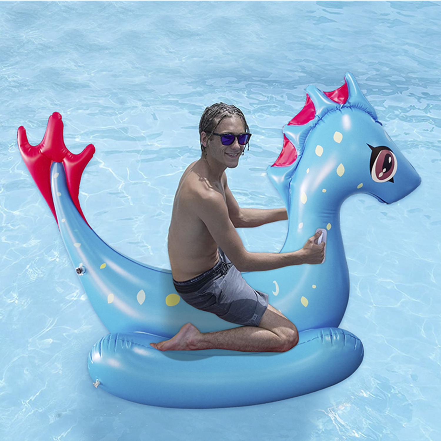 Hombre en un inflable de caballito de mar azul en una piscina, gafas de sol.