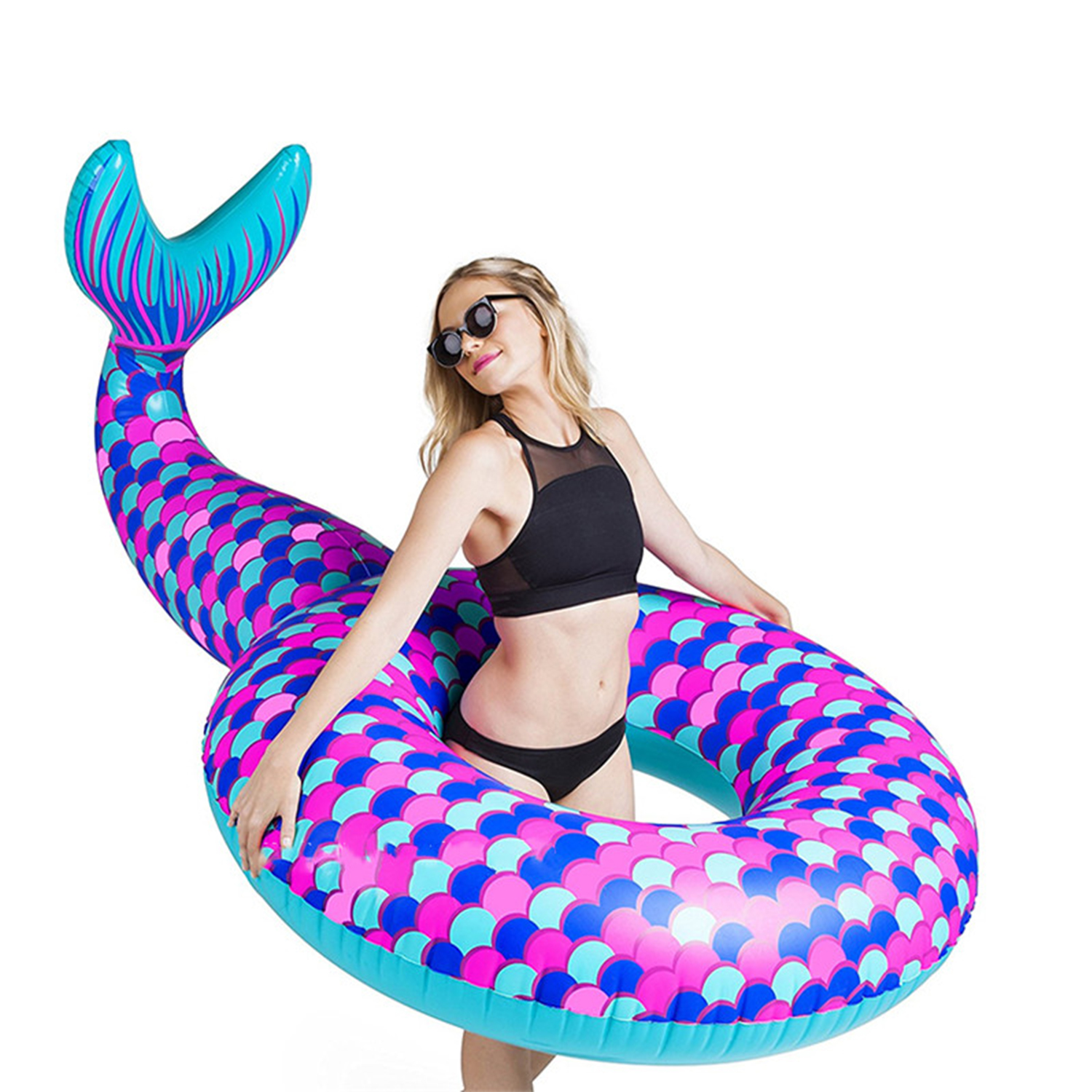 Donna con occhiali da sole tiene un galleggiante a coda di sirena. Il galleggiante è blu, rosa e verde acqua. Sfondo bianco.