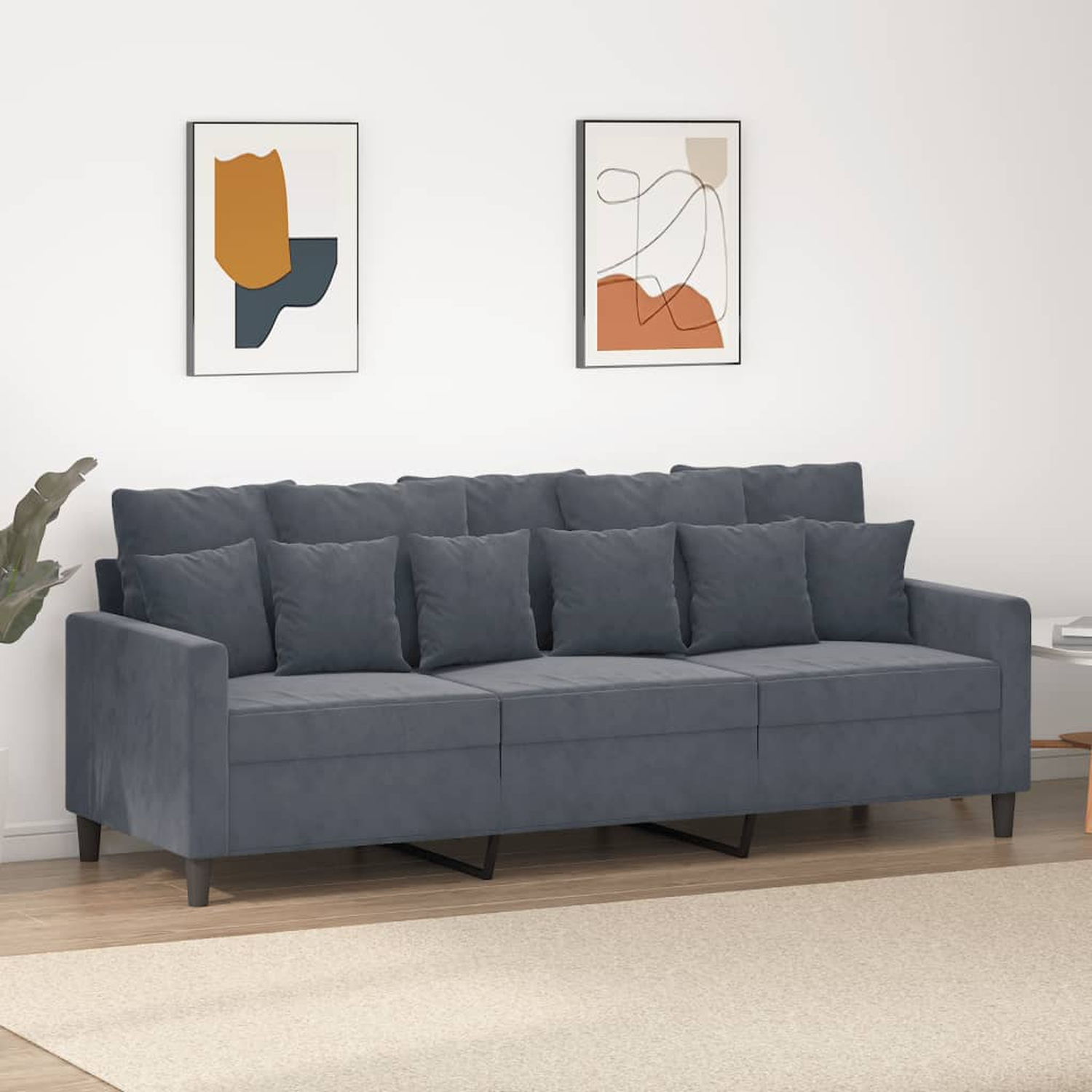 Graues Sofa mit mehreren Kissen, auf einem weißen Teppich. Weißer Hintergrund.