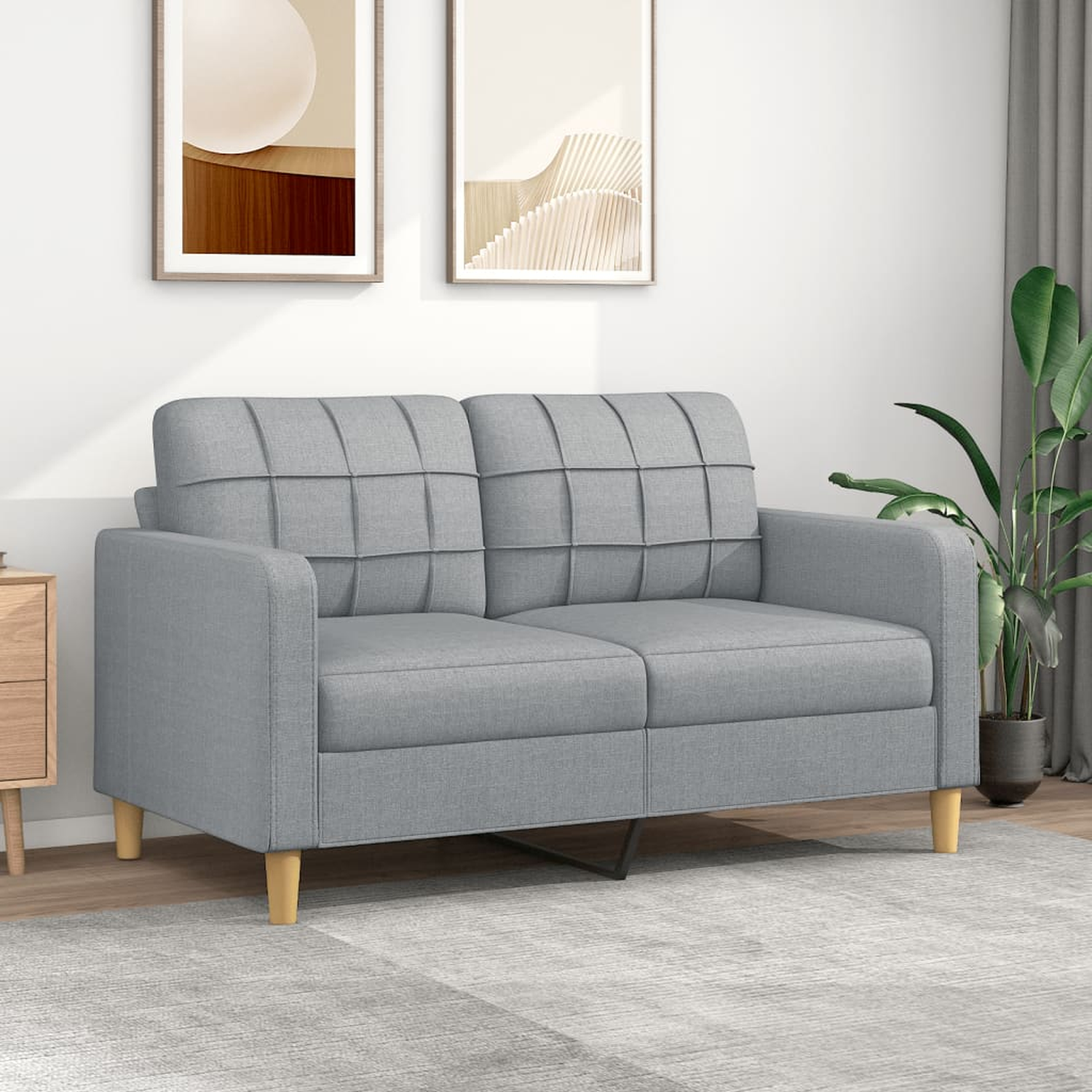 Graues Zweisitzer-Sofa mit Holzbeinen vor einer Wand mit Gemälden.
