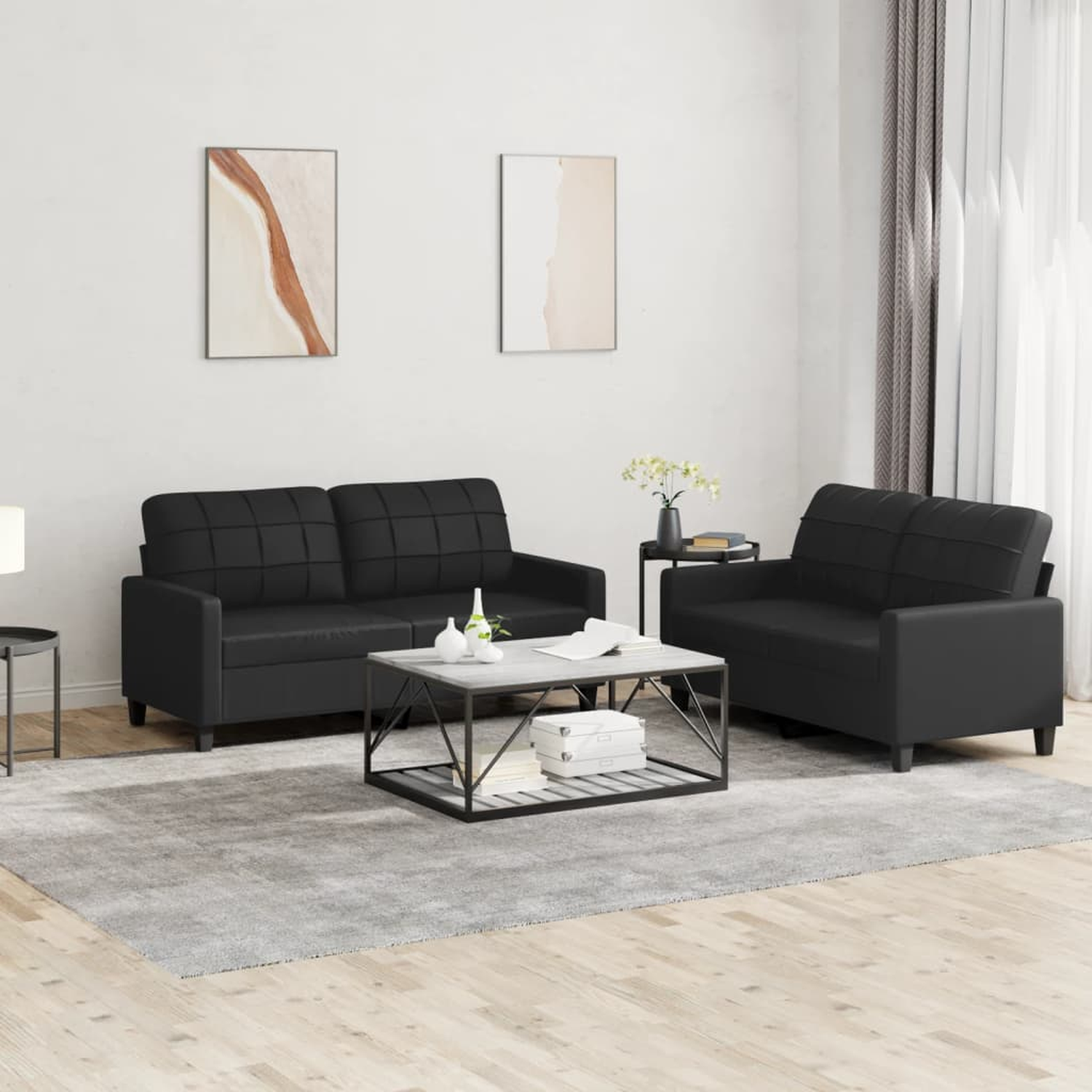 Wohnzimmer mit schwarzem Ledersofaset, Couchtisch und Teppich. Neutrale Farben.