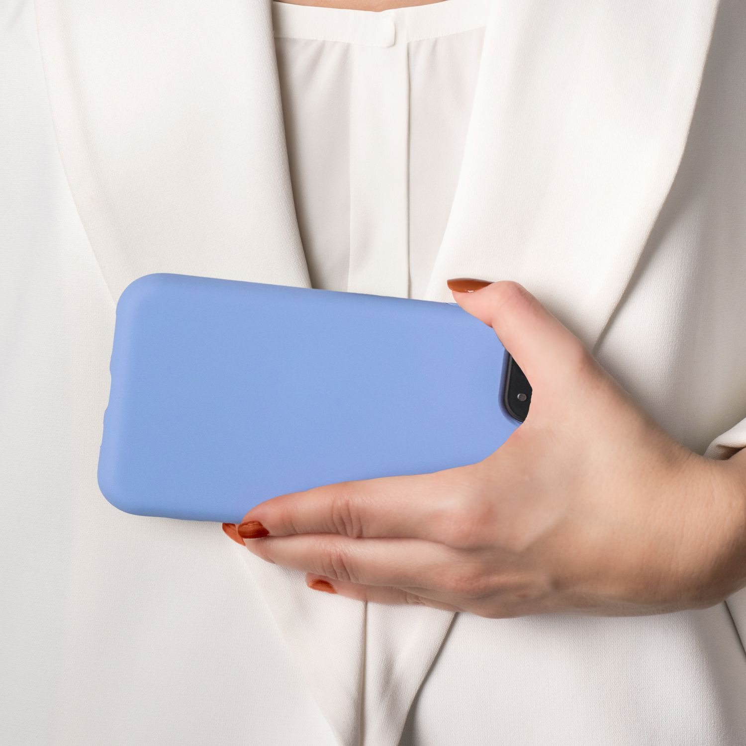 Person hält eine blaue Handyhülle über einem weißen Blazer.