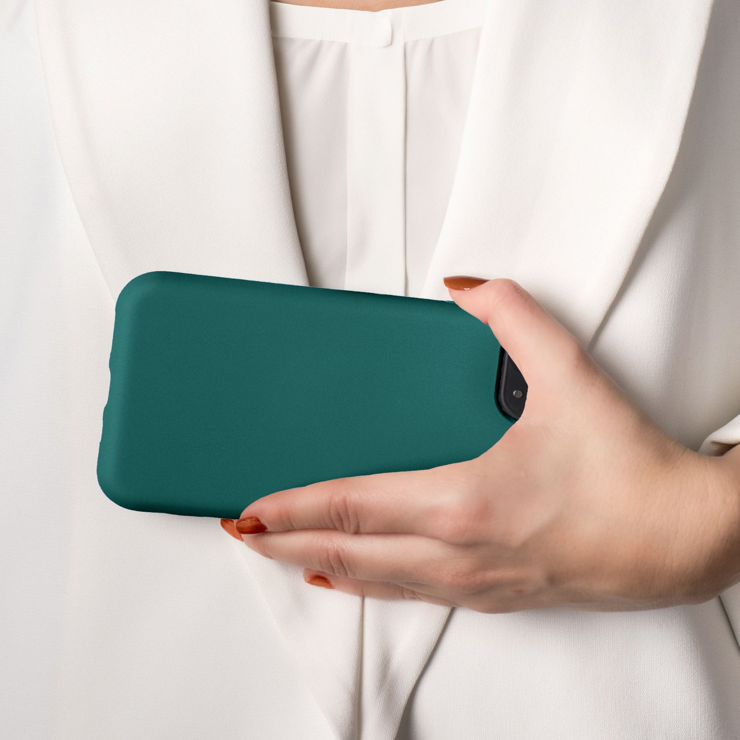 Eine Hand, die eine türkisfarbene Handyhülle hält, mit einem weißen Blazer im Hintergrund.
