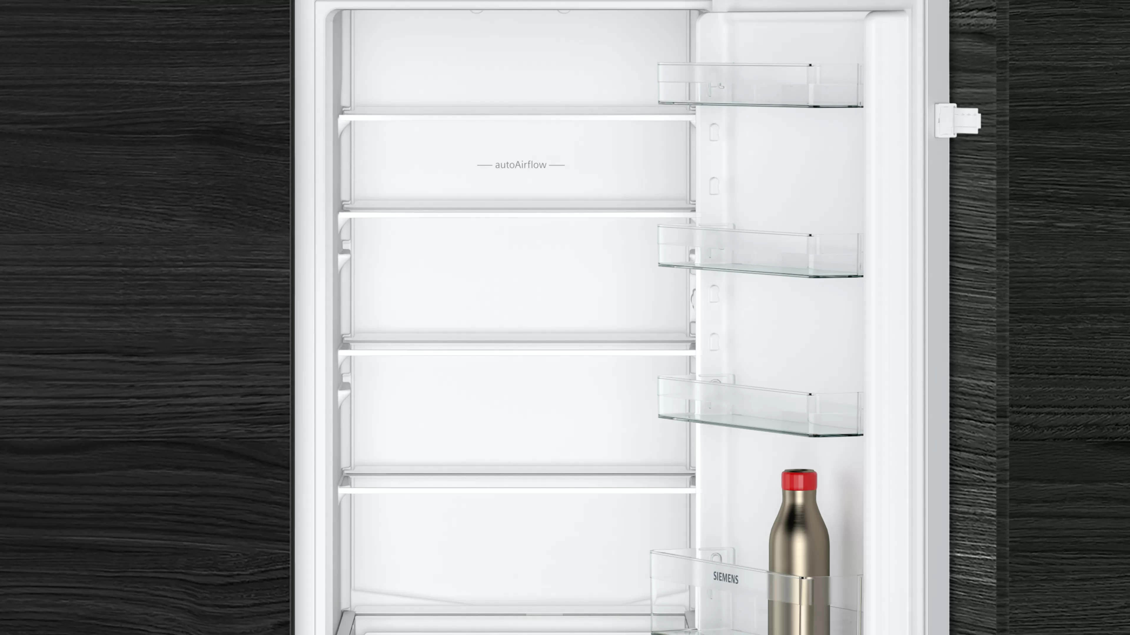 Otwarta lodówka z półkami i butelką. Ciemne drewniane tło.