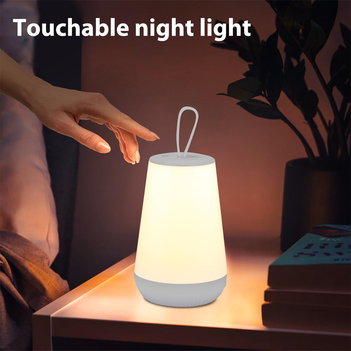 Berührbare Nachtlampe. Hand berührt sie. Pflanze und Bücher auf dem Tisch.