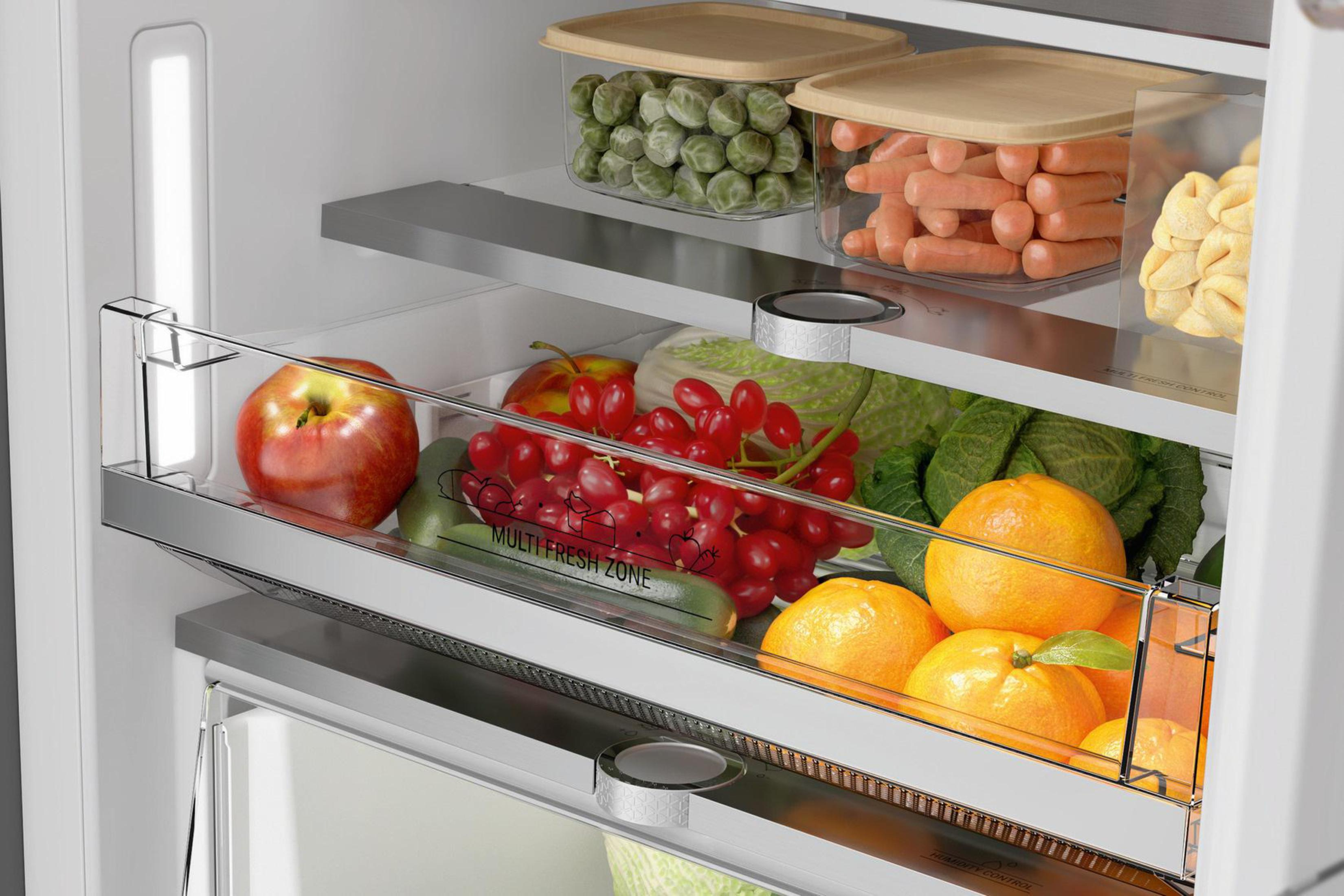 Kühlschrank-Innenraum mit frischen Produkten in Schubladen und auf Regalen.