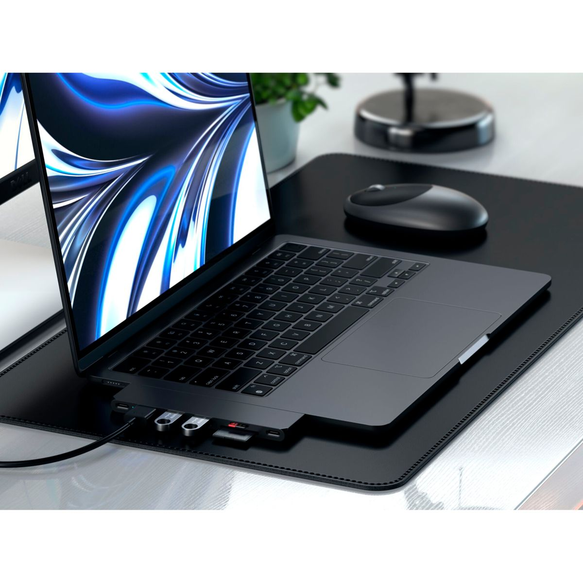 Ordenador portátil con concentradores USB y otros dispositivos sobre una superficie negra. Se ve un ratón.