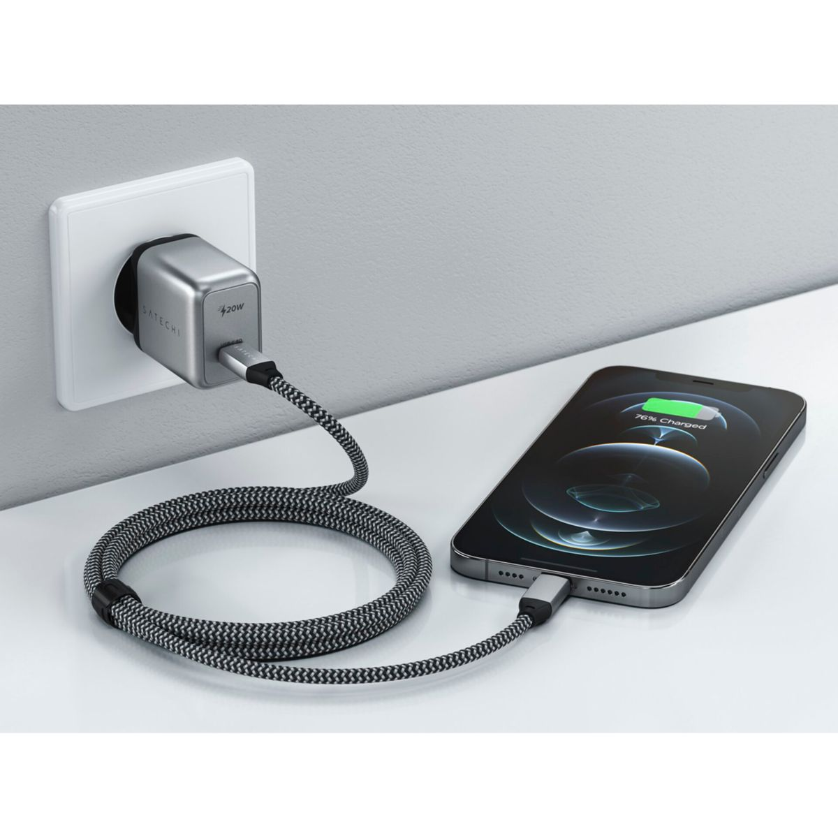 Ein Telefon, das mit einem Ladegerät geladen wird, das in eine Steckdose eingesteckt ist.