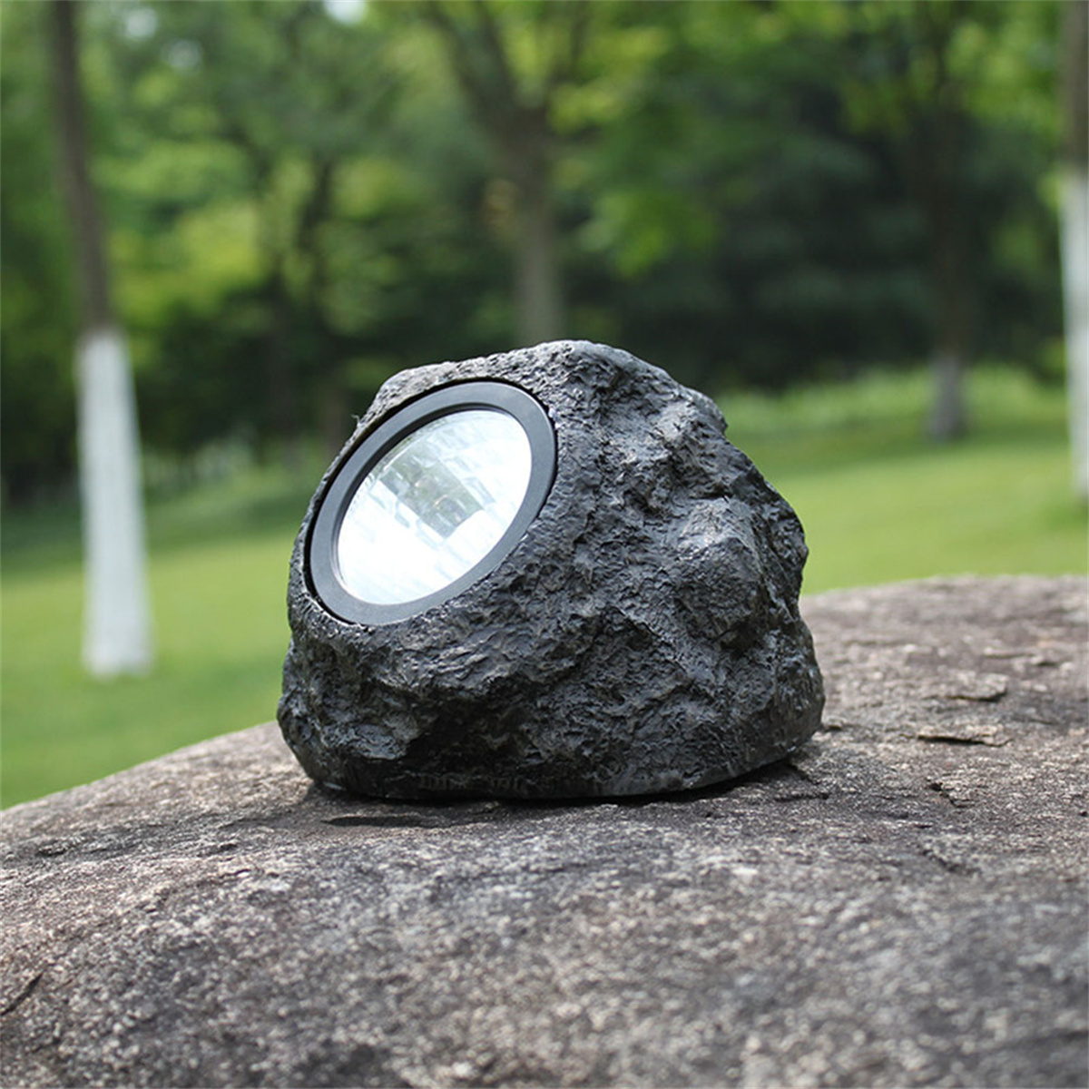 Felsenförmige Außenleuchte. Schwarz, mit kreisförmigem Licht auf der Vorderseite.