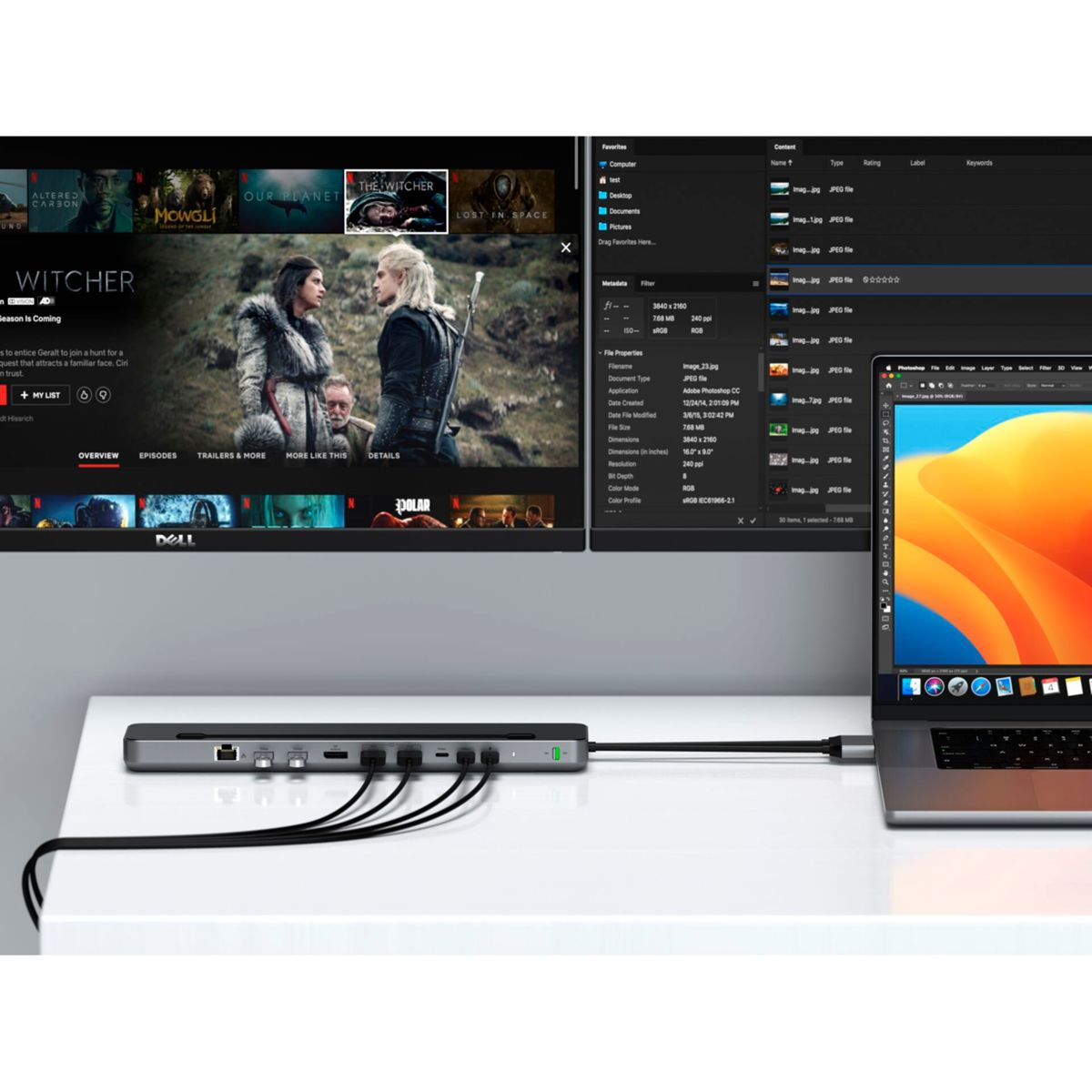 Laptop collegato a un hub con TV che mostra un film.