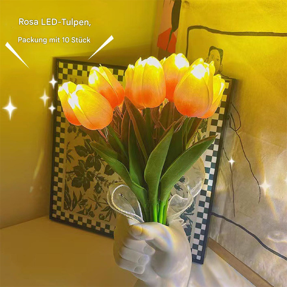 Strauß gelb-oranger LED-Tulpen in weißer handförmiger Vase, vor gemustertem Hintergrund.