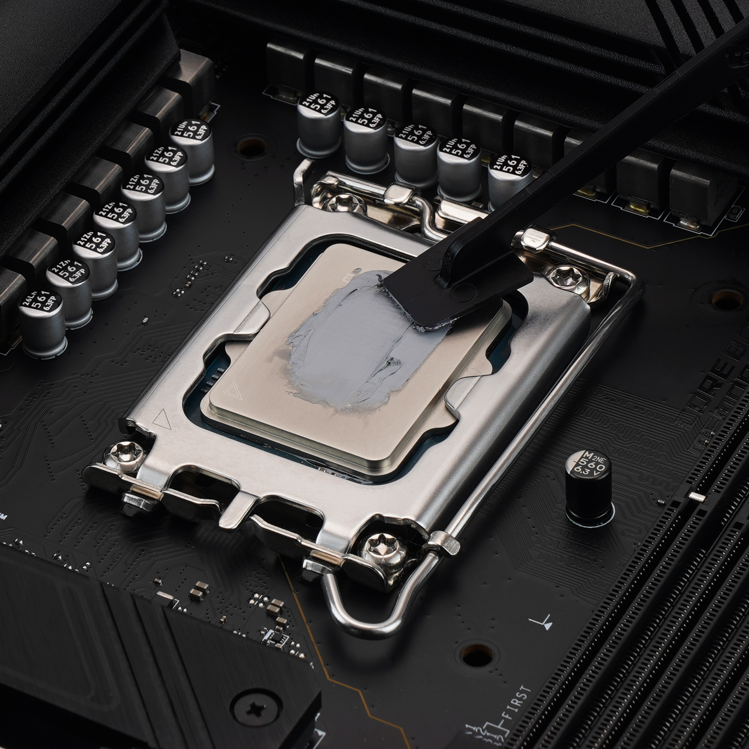 Primer plano de una CPU con pasta térmica aplicada sobre la CPU en una placa base negra.