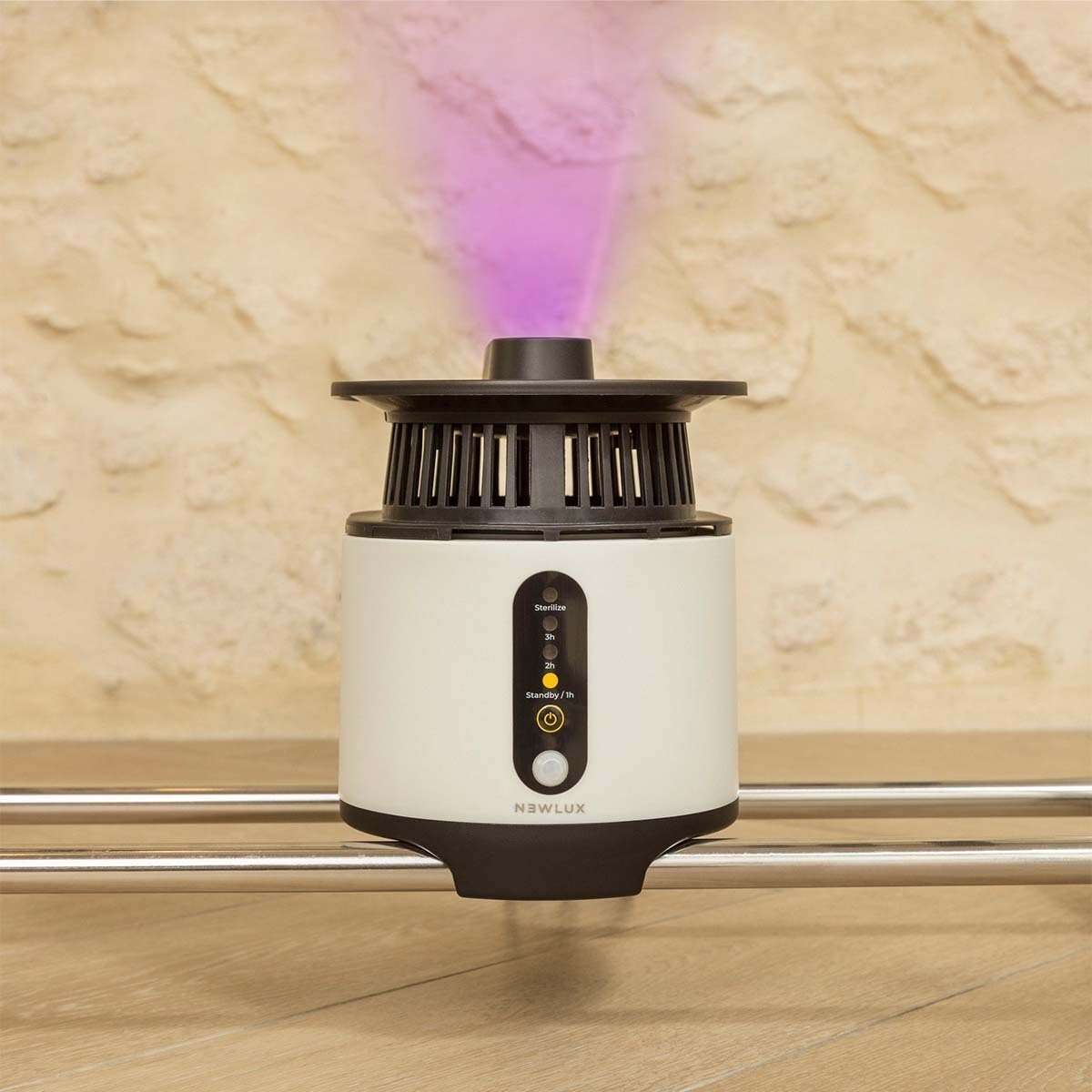 Purificador de aire con luz púrpura, sobre superficie de madera.
