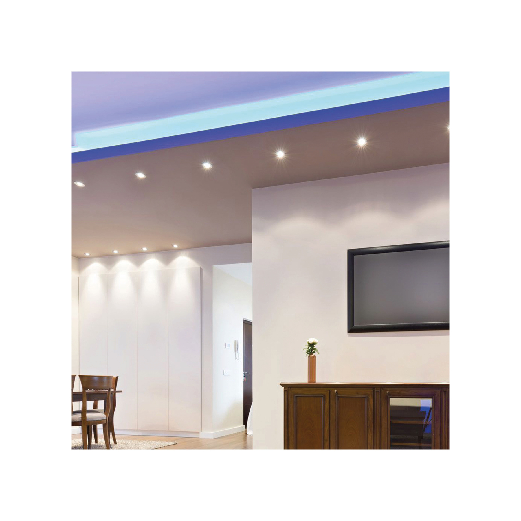 Interno con luci a soffitto, pareti bianche, un mobile e una TV. Lo sfondo mostra una porta.