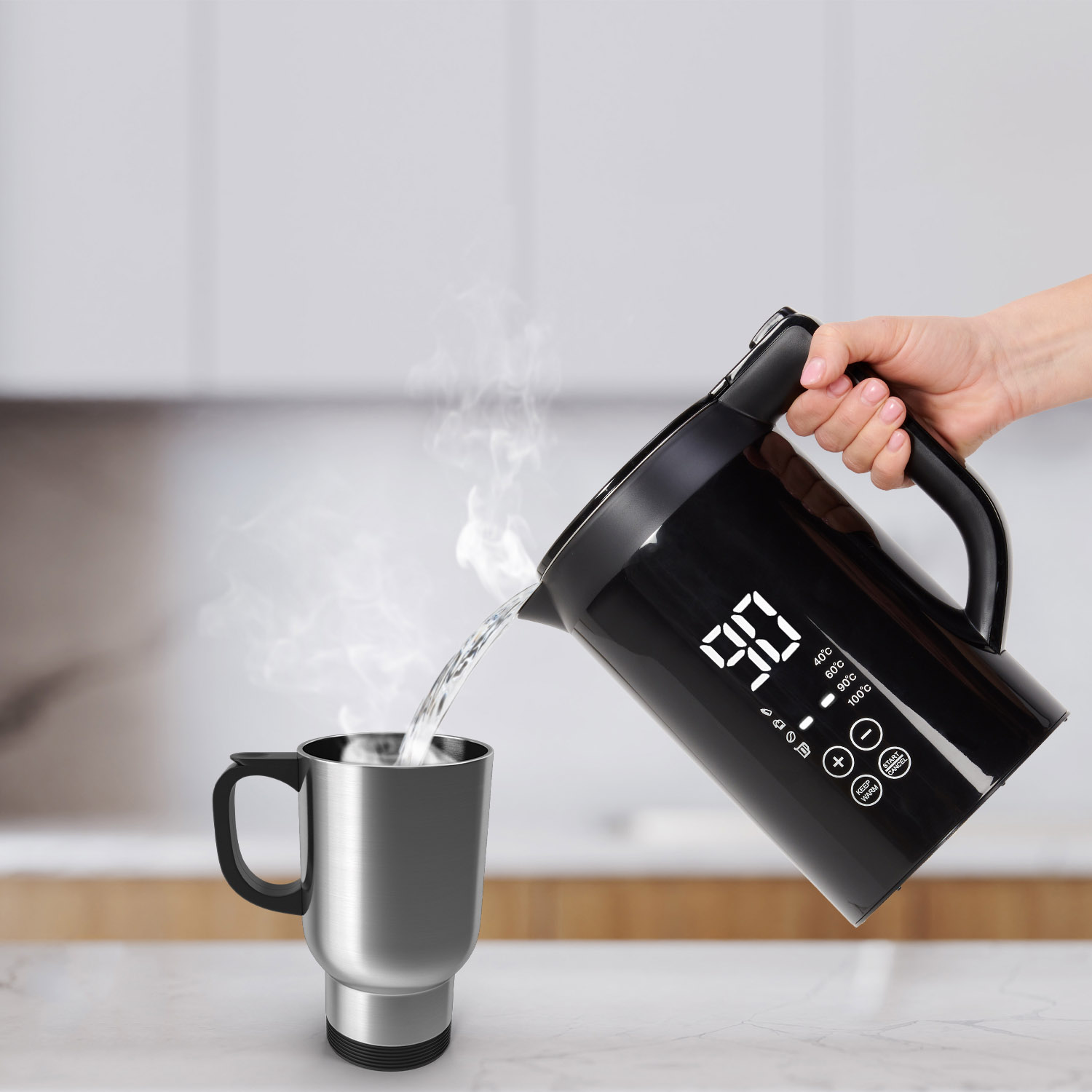 A black kettle pouring water into a silver mug.