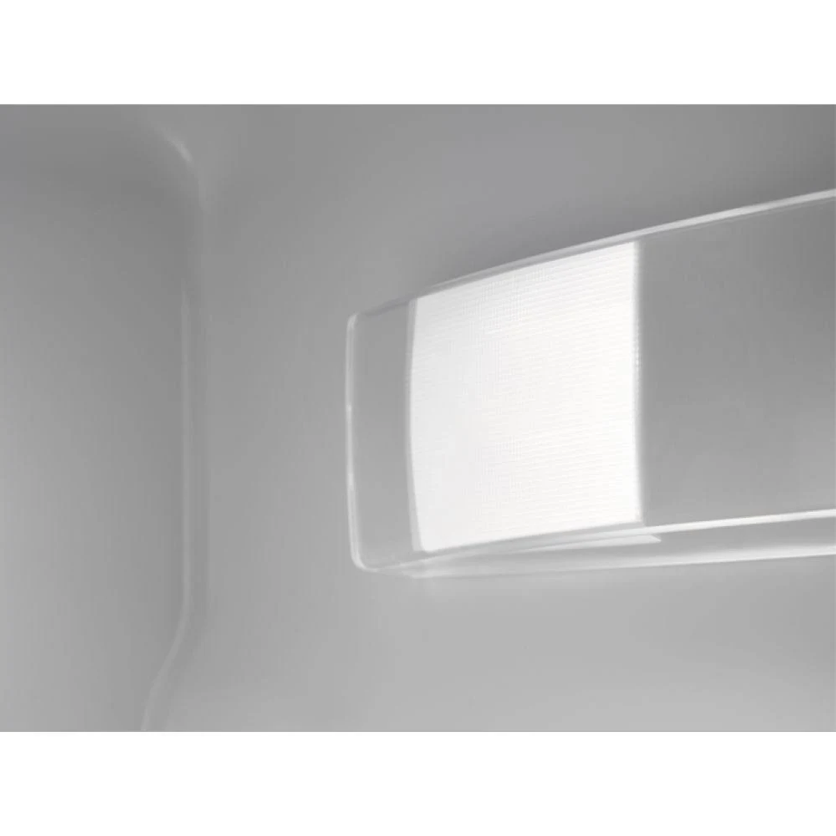 Primo piano di una sorgente luminosa brillante all'interno di un elettrodomestico bianco, forse un frigorifero.