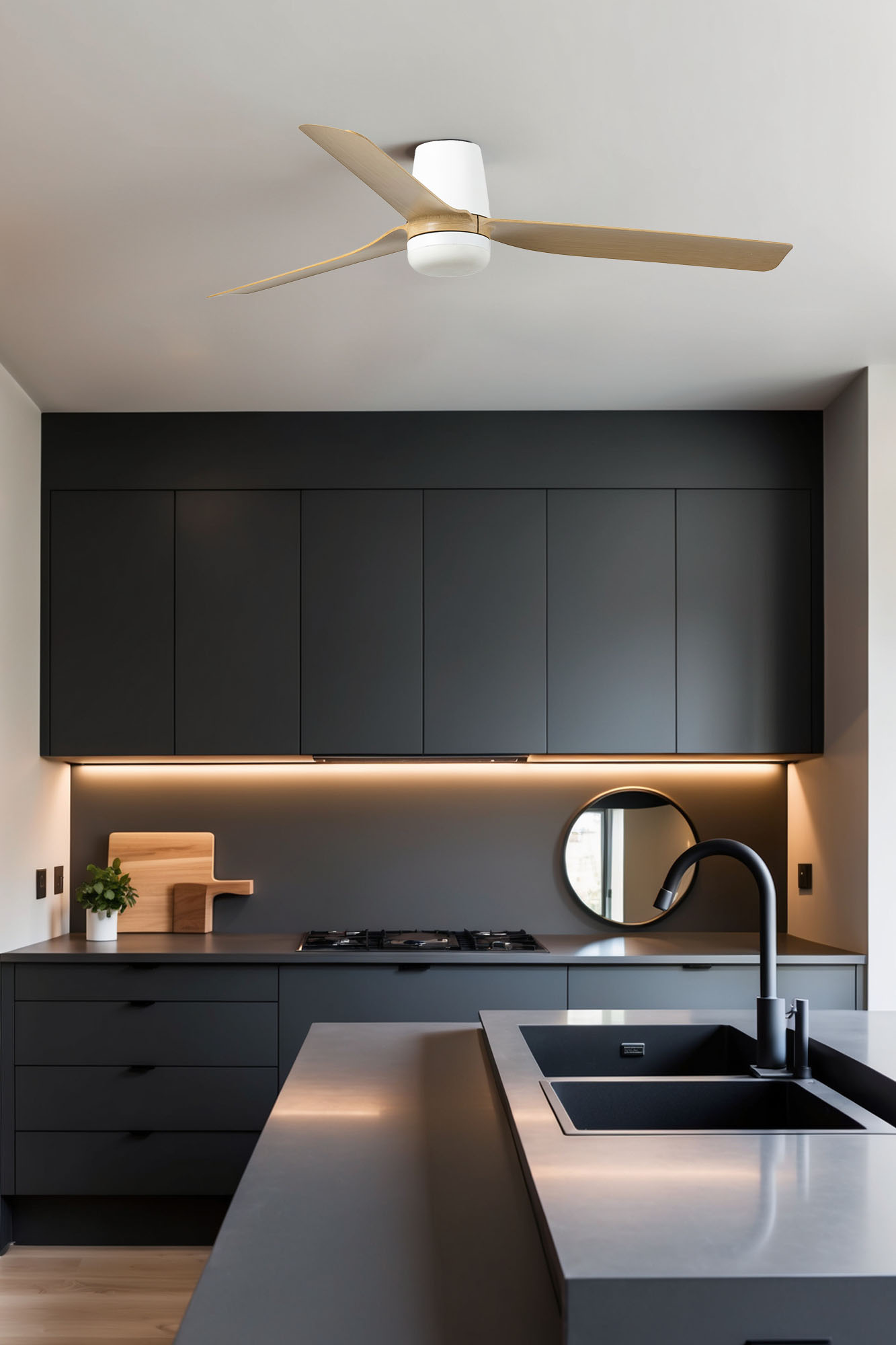 Una cucina moderna con mobili scuri, un ventilatore a soffitto e un piano di lavoro con lavello.