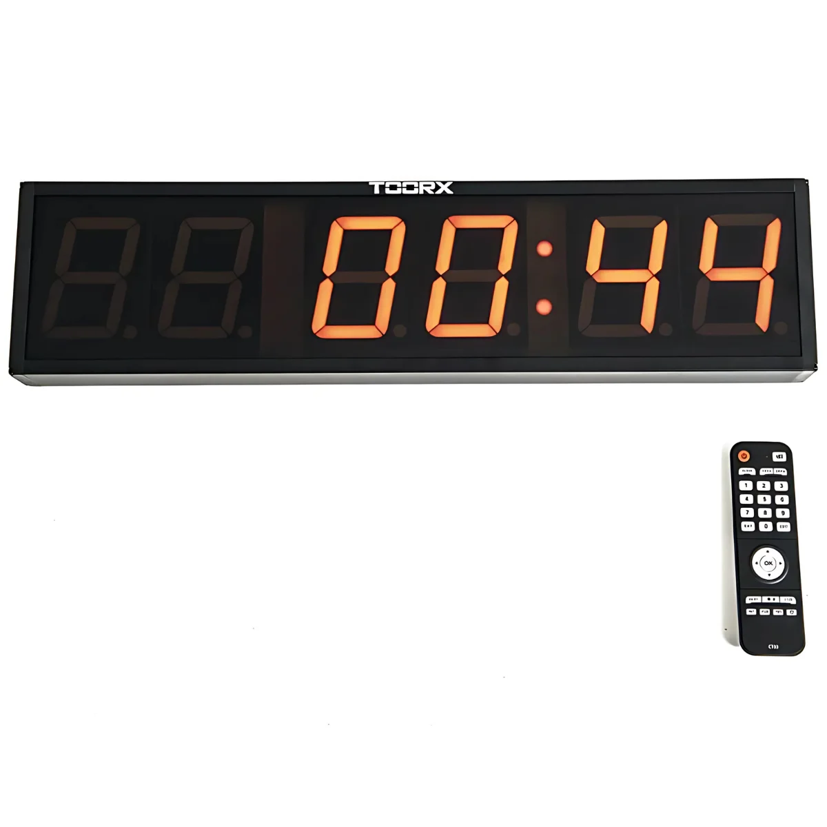 Horloge numérique noire avec des chiffres orange. Une télécommande est en dessous.
