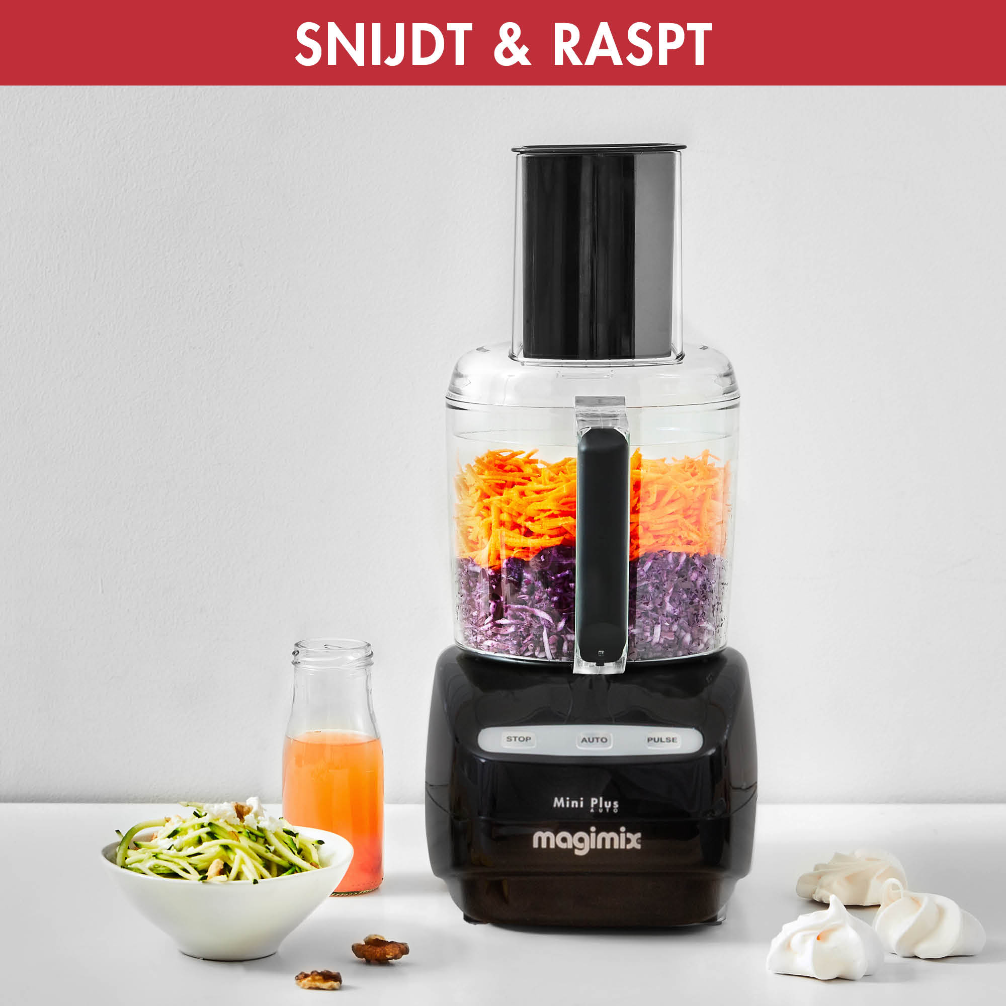 Keukenmachine met gehakte groenten en sinaasappelsap.