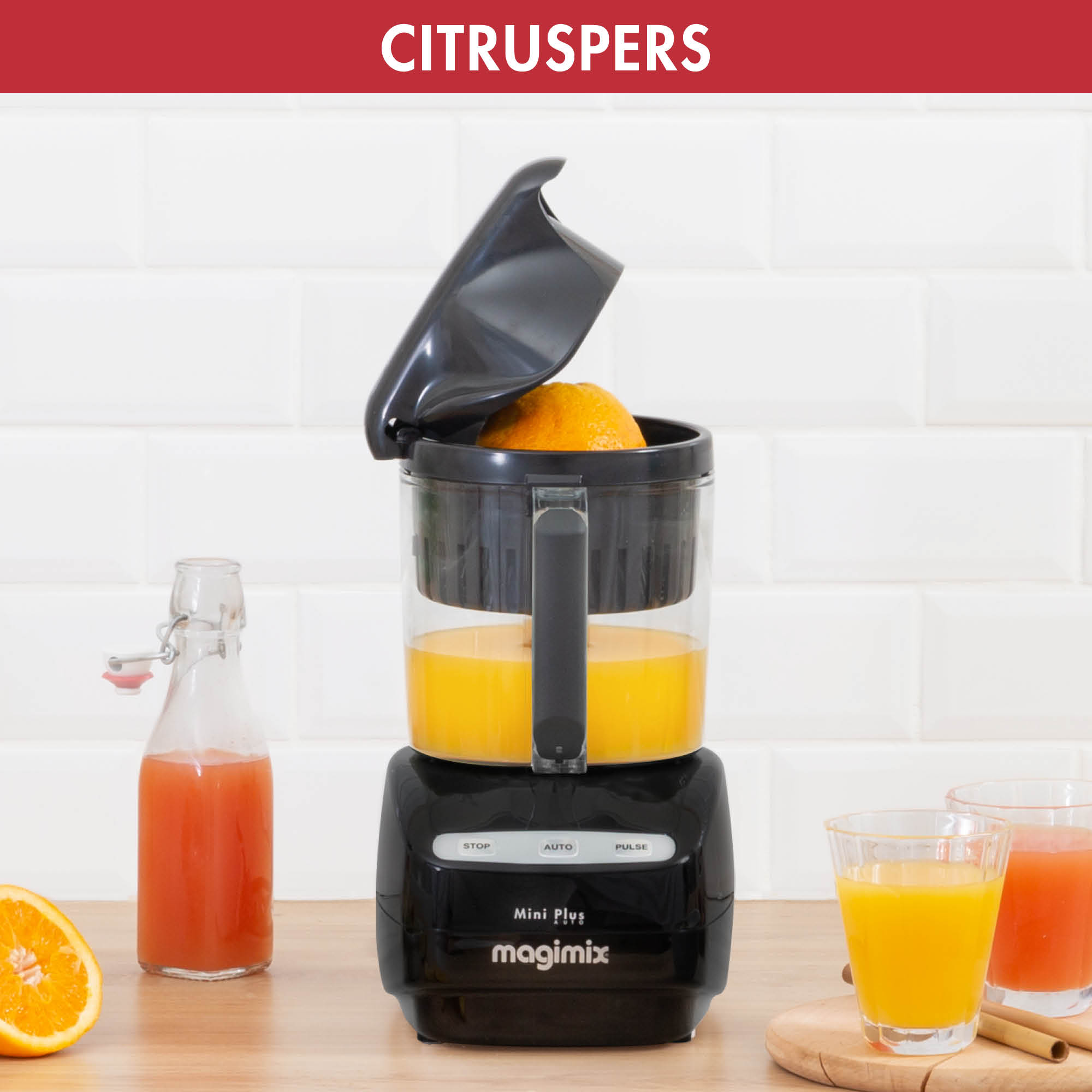 Een zwarte en zilveren citruspers met een sinaasappel erin en sap in glazen.