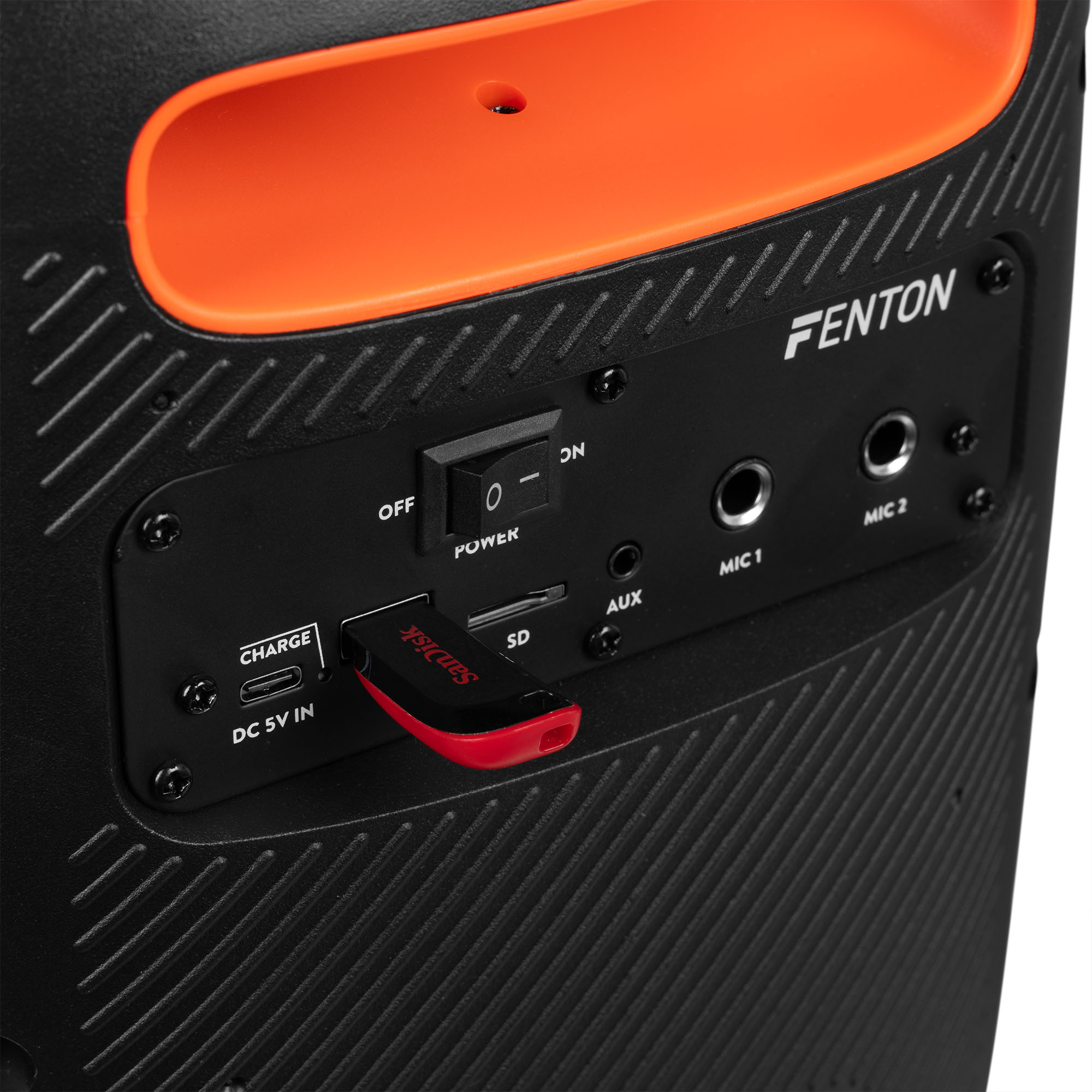 Parte trasera de un altavoz negro con puertos USB, AUX y micrófonos, con una parte superior naranja.